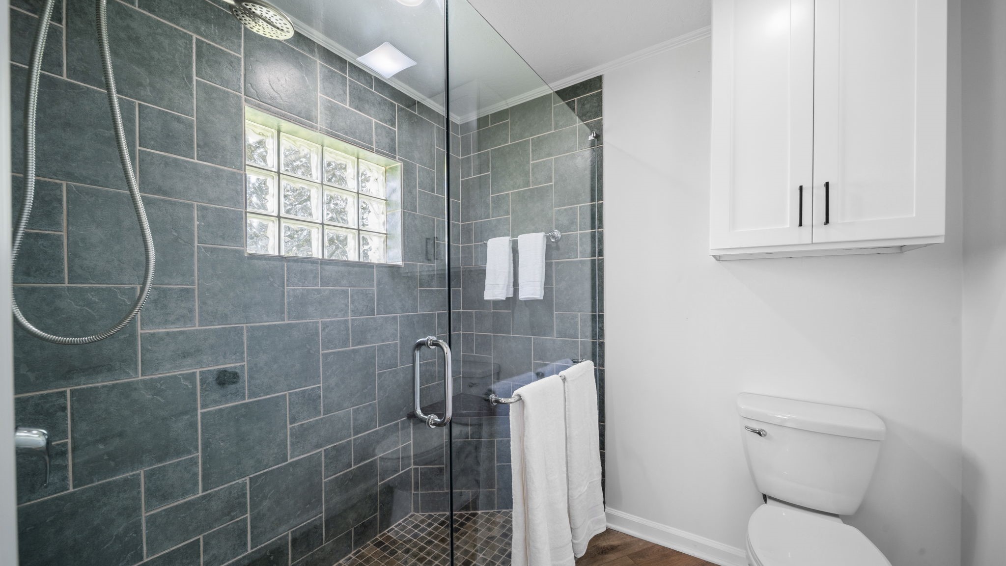 Private Primary Shower Large walk in shower, natural light and with built in cabinet
