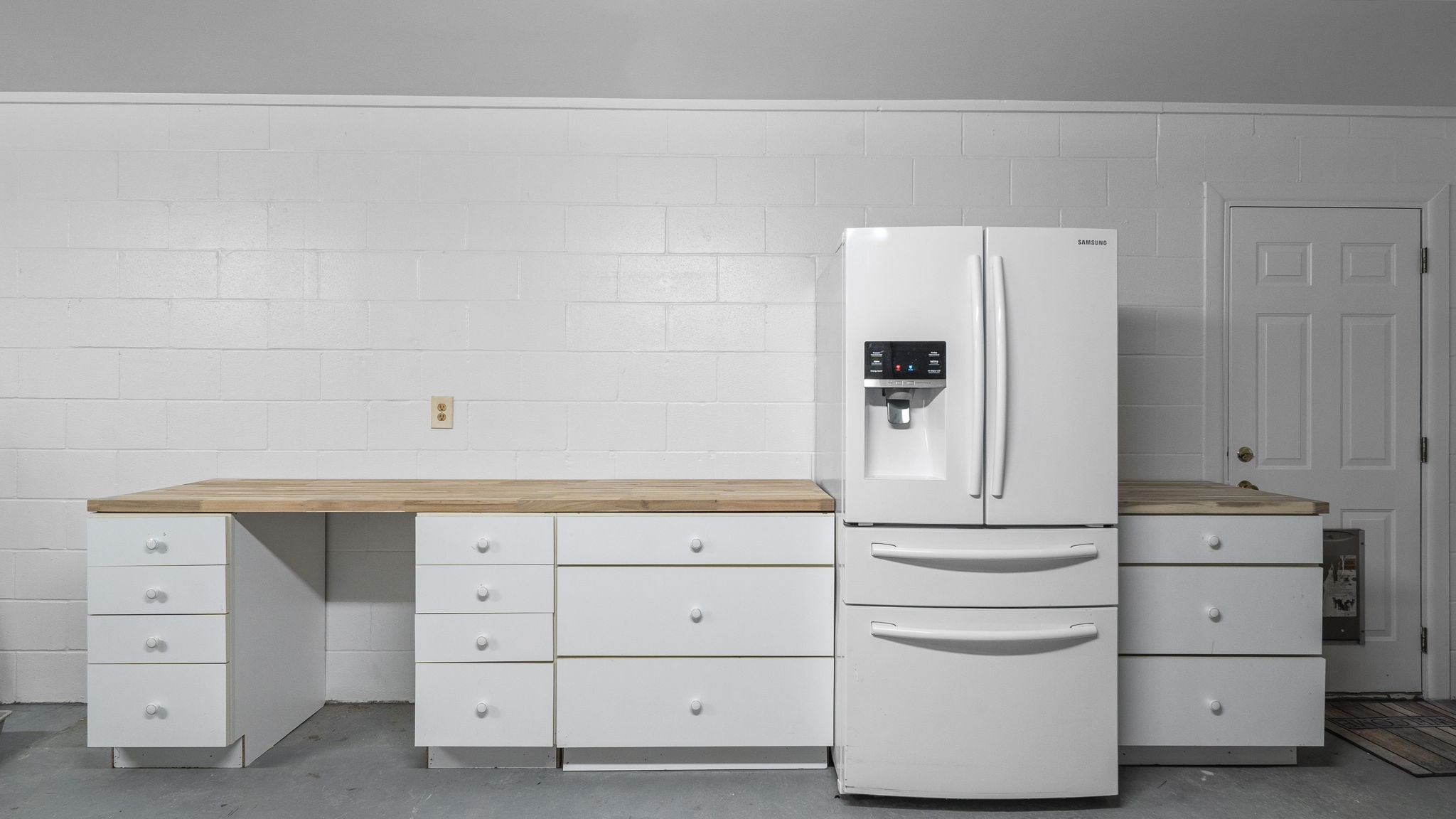 3 car garage with work space. Work bench and storage with Refrigerator