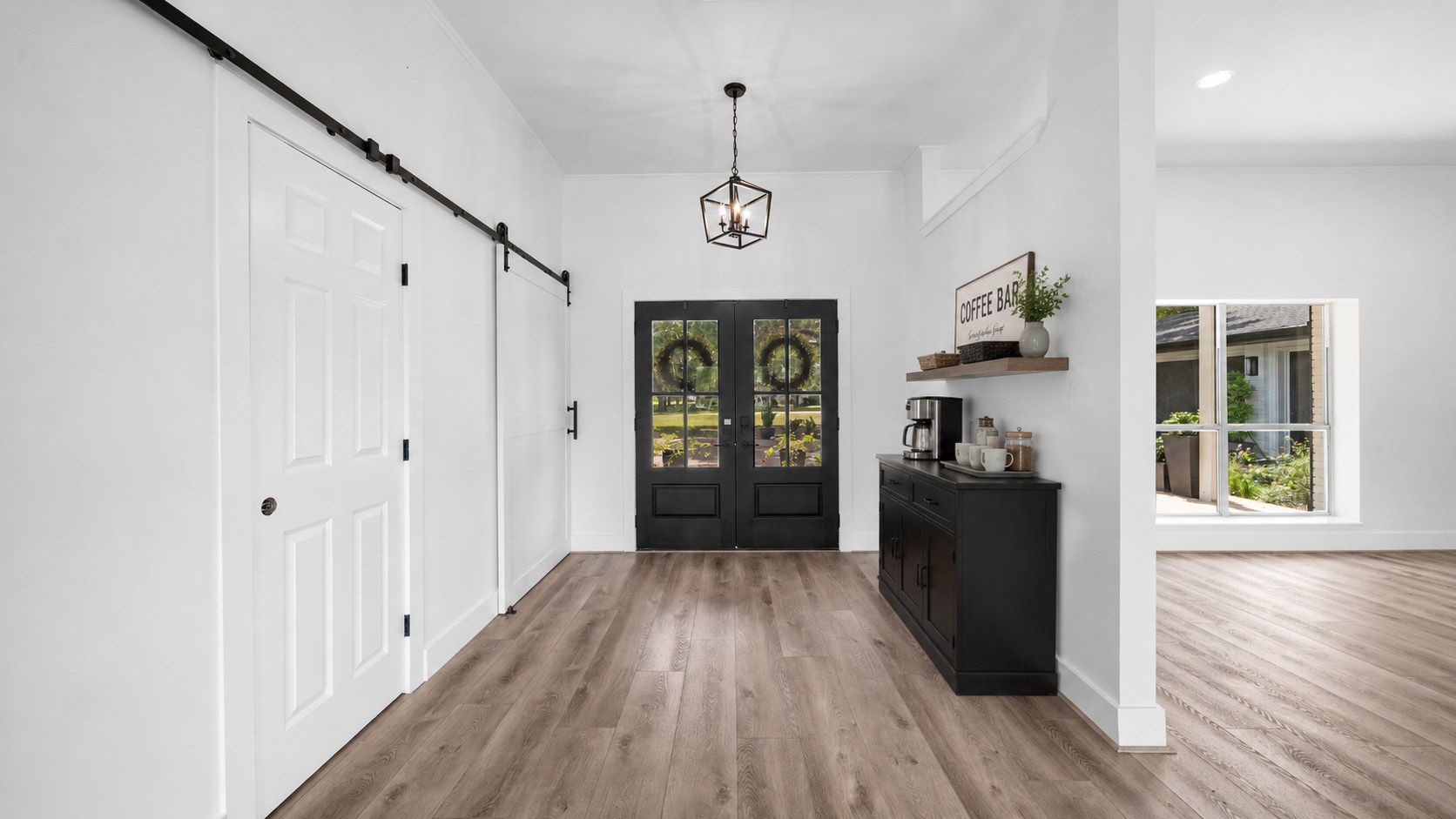 Staged entry Barn doors lead to hallway to Primary bedroom and hallway to 2 of the secondary bedrooms, bath and linen closet
