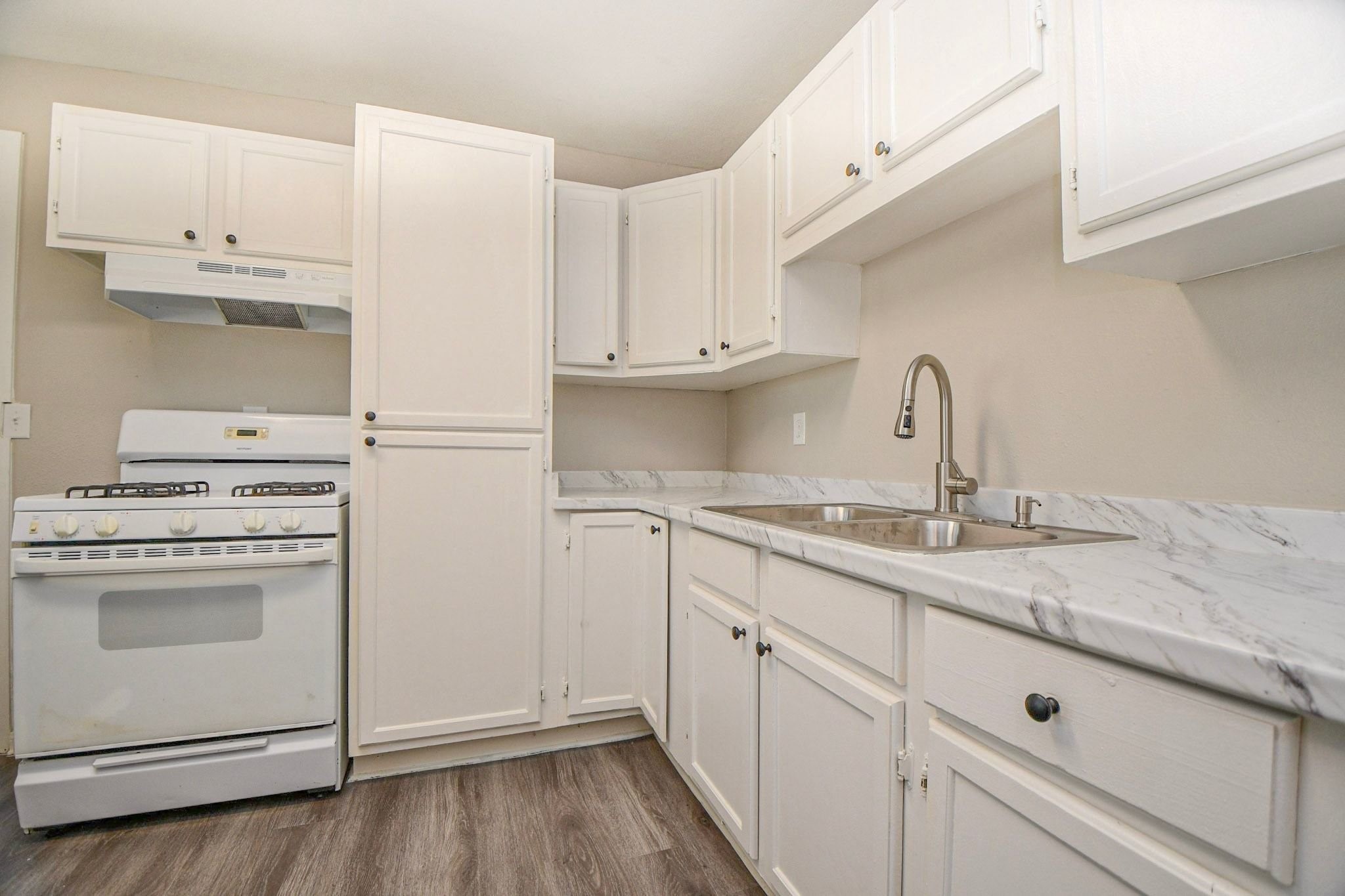 Kitchen features crisp white cabinets, marble-look countertops. Kitchen features crisp white cabinets, marble-look countertops.