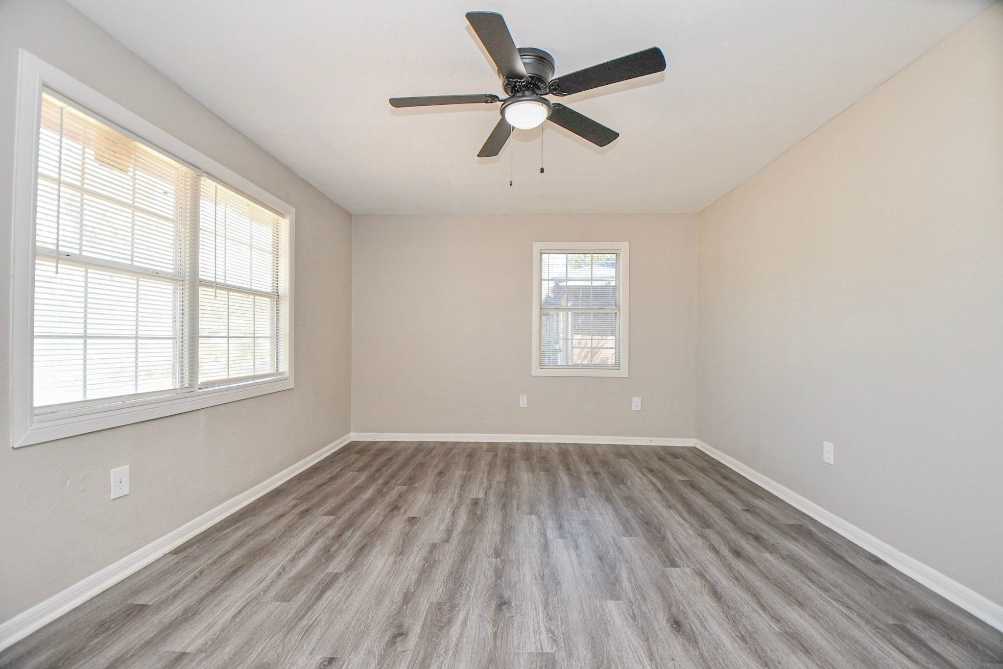 Living area features large windows that bring in natural light, complemented by a ceiling fan for added comfort and a bright, welcoming atmosphere. Living area features large windows that bring in natural light, complemented by a ceiling fan for added comfort and a bright, welcoming atmosphere.