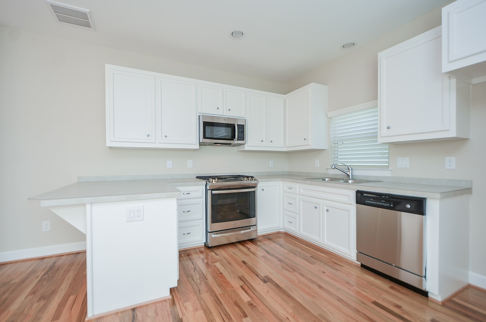 White cabinets, pull out drawers, and stainless appliances provide the storage and tools needed to make this kitchen a chefs dream.