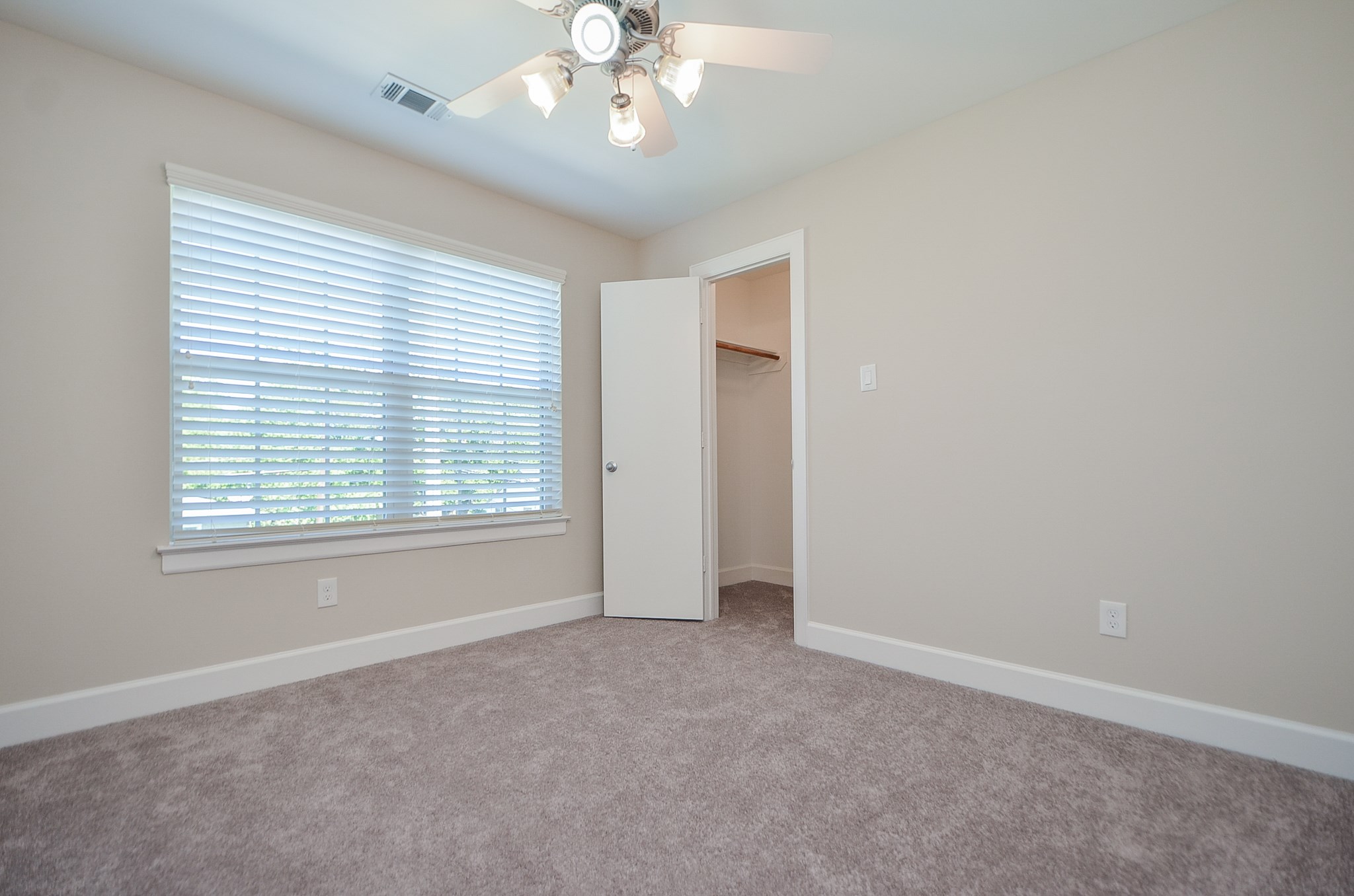 Down the hall from the master are two spacious secondary bedrooms.  Each bedroom has a walk in closet, neutral paint, plush carpet. and a ceiling fan.
