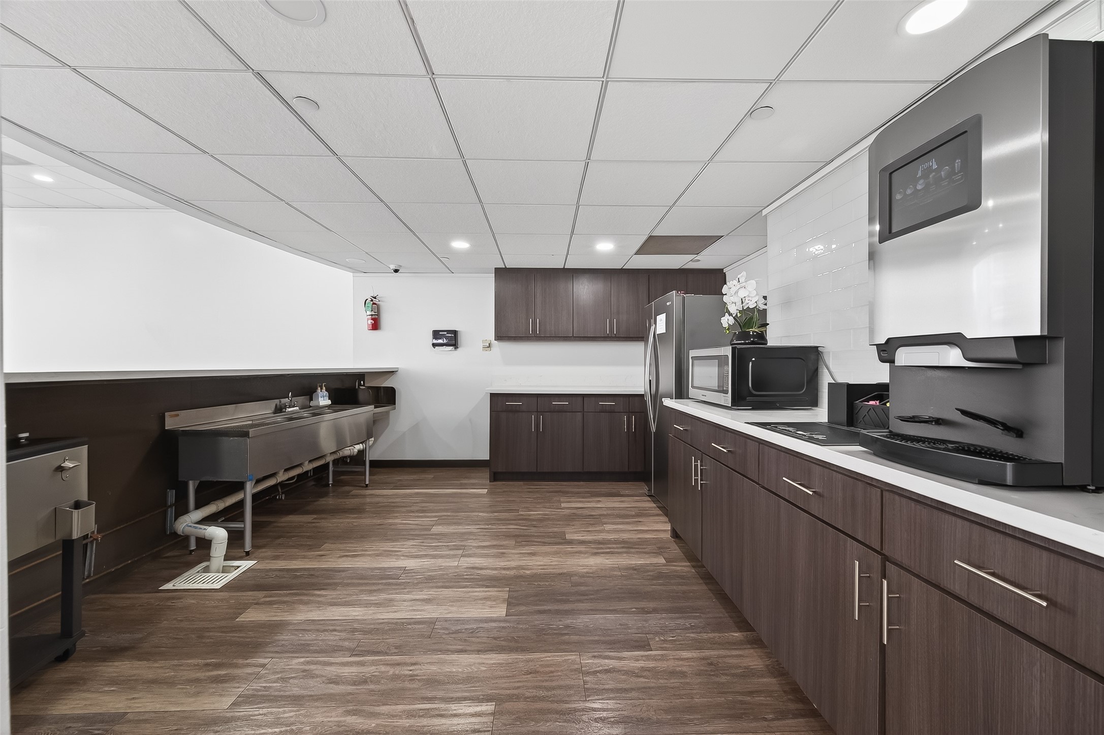Modern kitchen with sleek dark wood cabinetry, stainless steel appliances, and ample counter space, perfect for culinary enthusiasts.