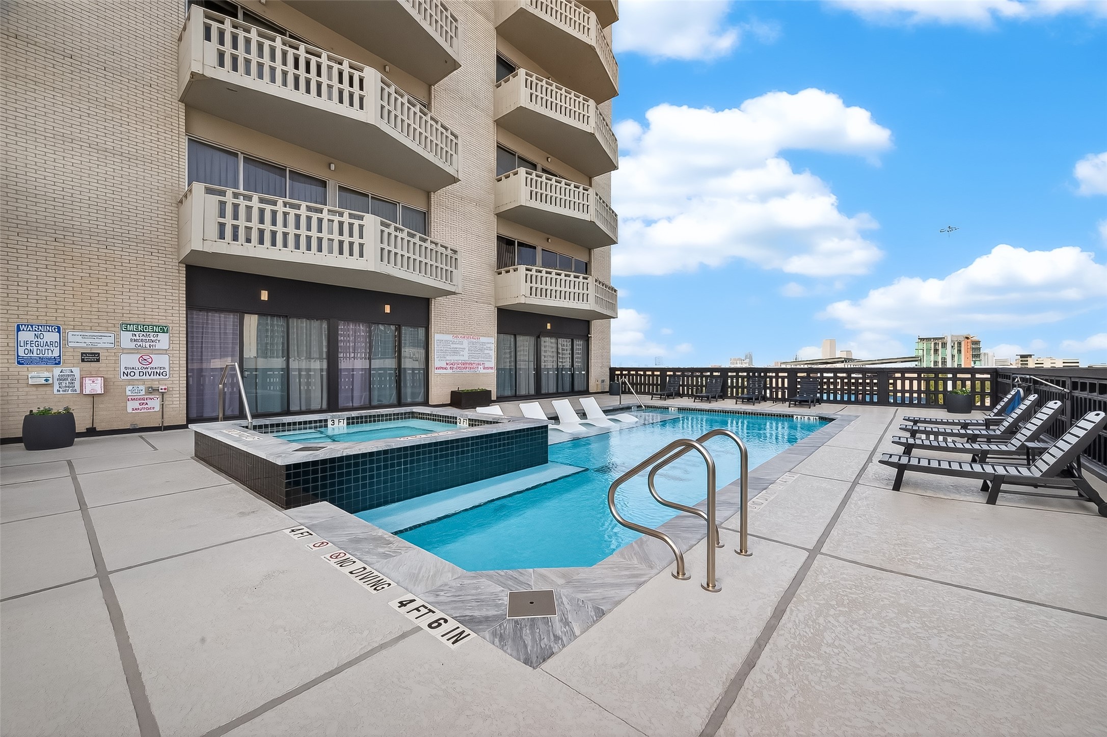 Stylish rooftop pool area with ample lounge seating, perfect for relaxation and enjoying panoramic city views.