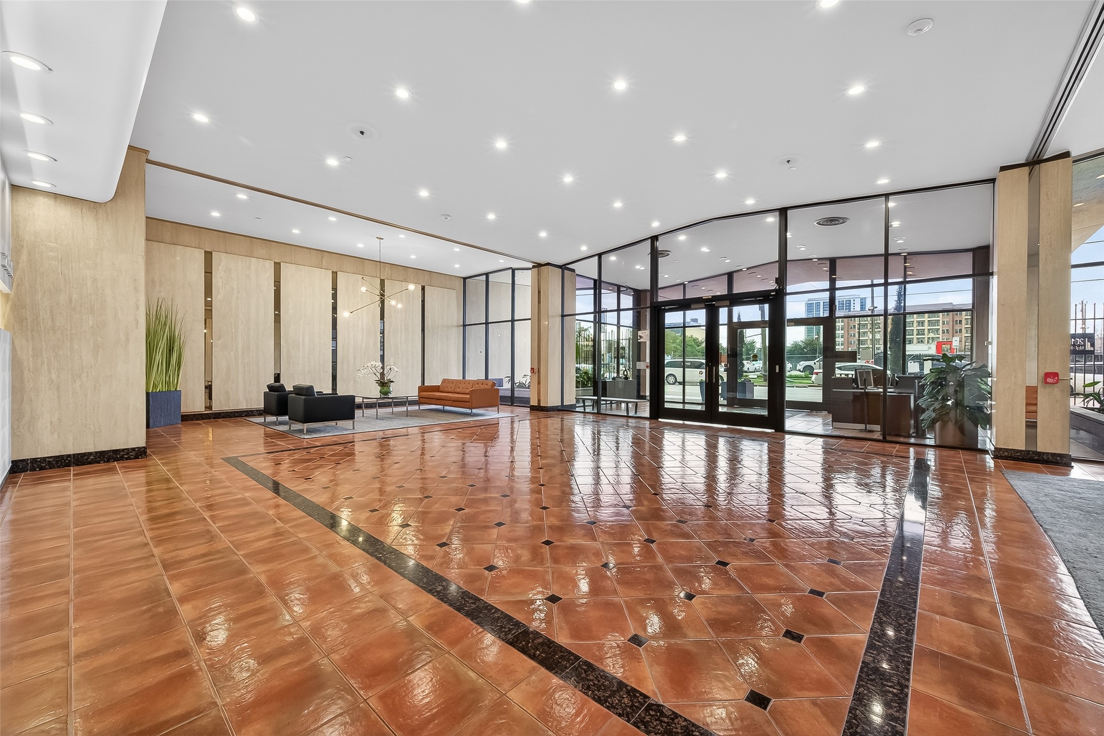 Spacious and elegant lobby with glossy tiled flooring, modern seating areas, and expansive floor-to-ceiling windows offering abundant natural light.