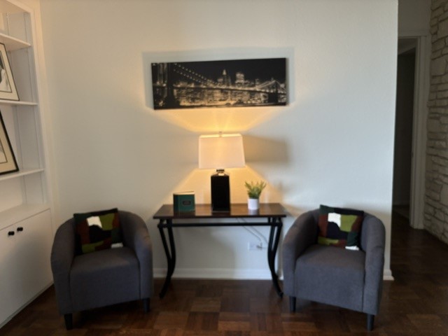 Cozy seating area with two stylish armchairs, a sleek table, and elegant decor, perfect for relaxing or entertaining.