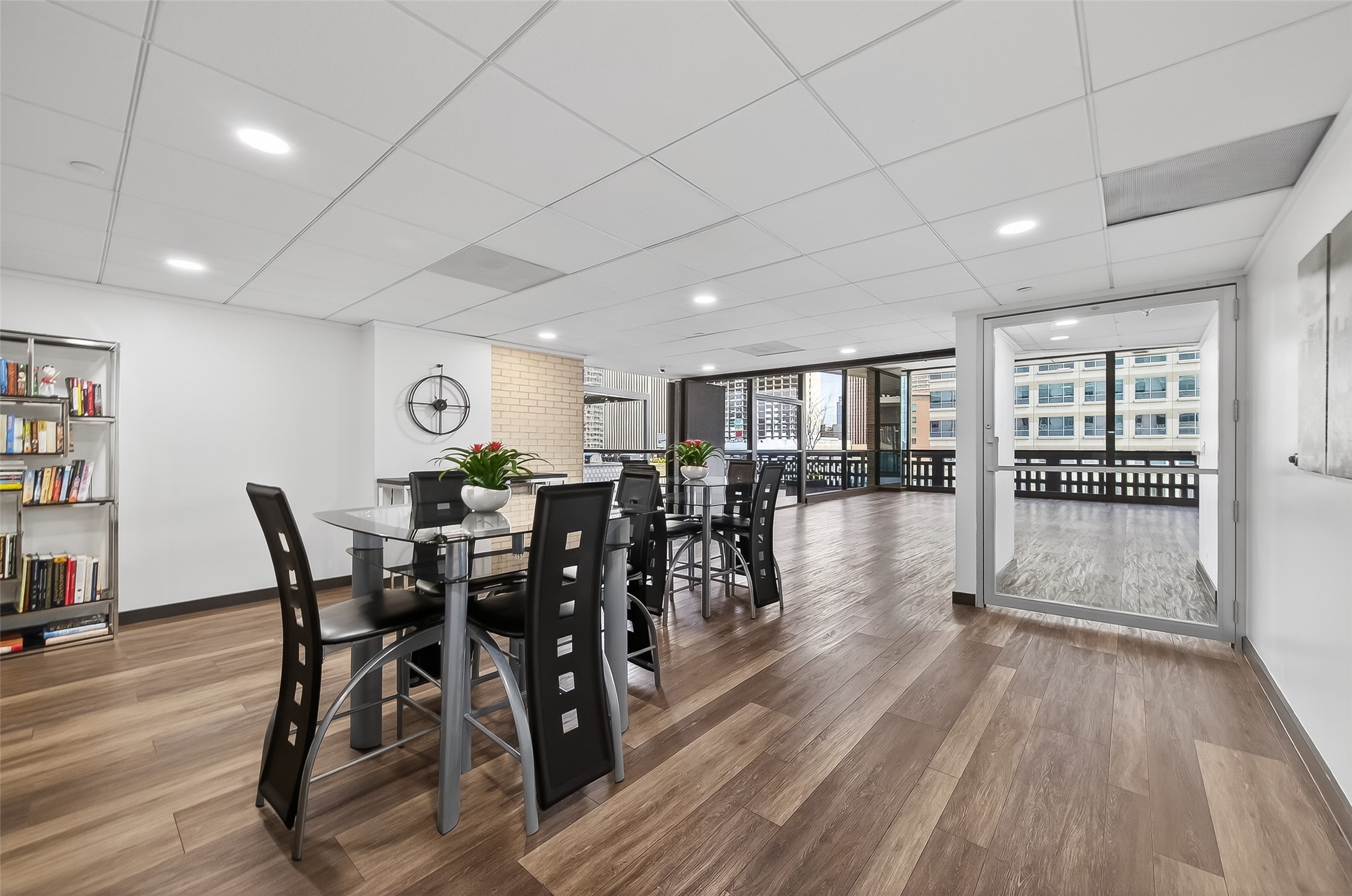 Spacious and modern dining area with sleek flooring, abundant natural light, and access to a large balcony offering city views.