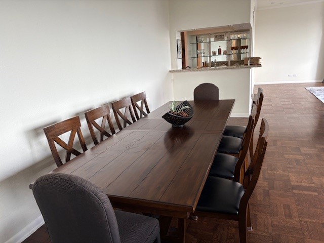 Elegant dining area featuring a long wooden table with stylish chairs, perfect for hosting gatherings. The open layout offers a seamless connection to adjacent spaces, enhancing the home's inviting atmosphere.