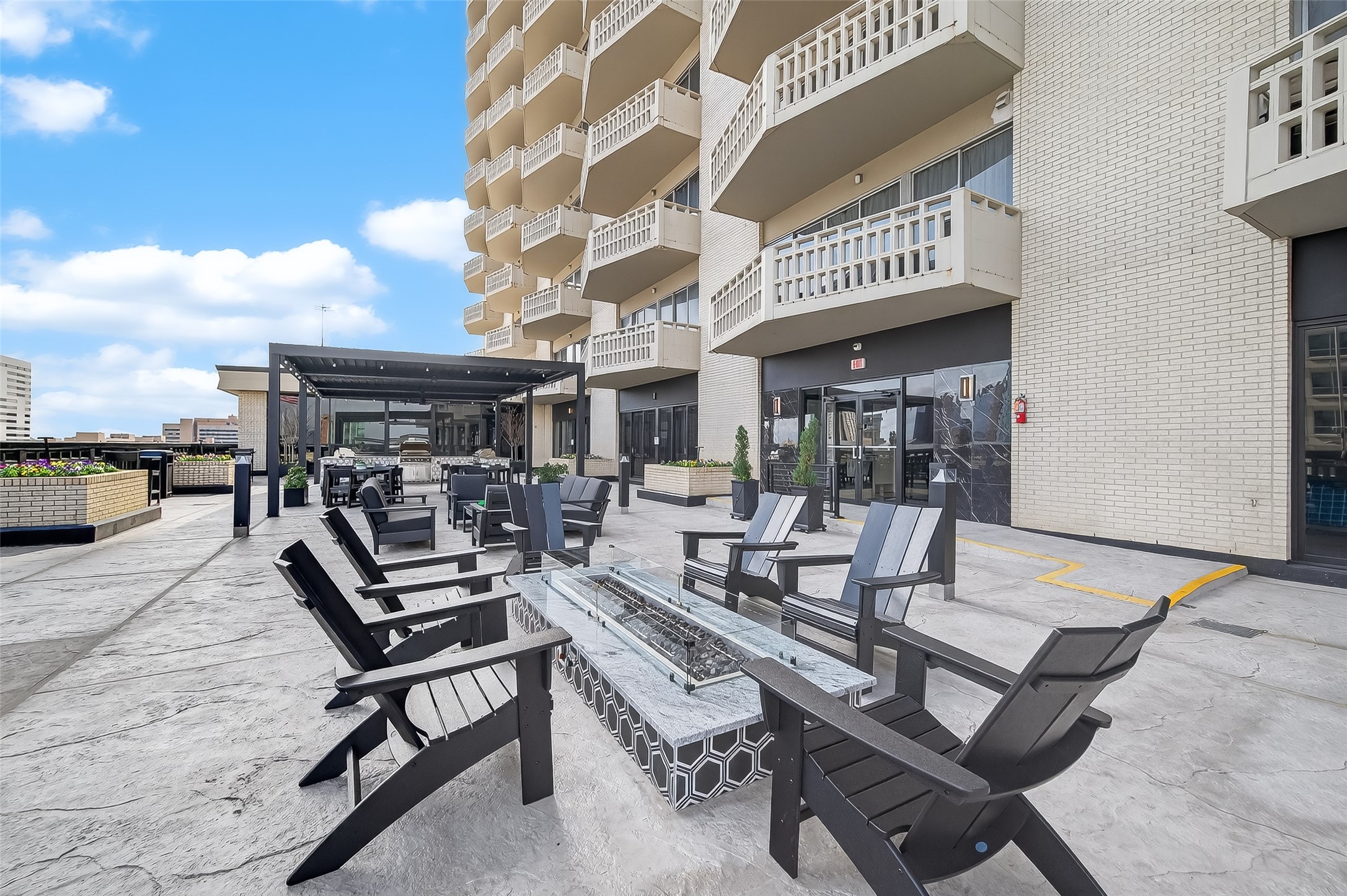 Spacious outdoor patio with comfortable seating and a modern fire pit, perfect for entertaining and enjoying city views.