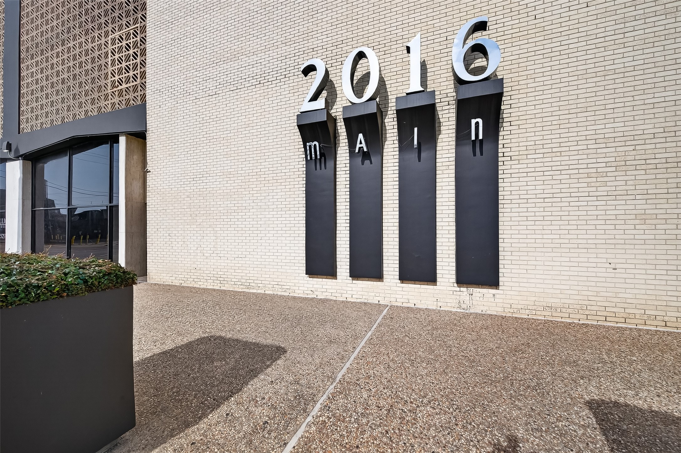 Modern building exterior with prominent street address signage and contemporary architectural details, offering a stylish urban vibe.