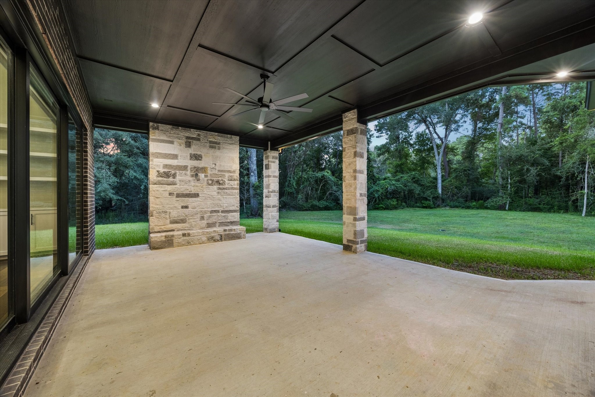 Seamlessly extending the home's living spaces outdoors, the expansive covered patio was designed for year-round entertaining. Prewired for an outdoor television and surrounded by peaceful wooded views, it creates the perfect setting for relaxed gatherings.