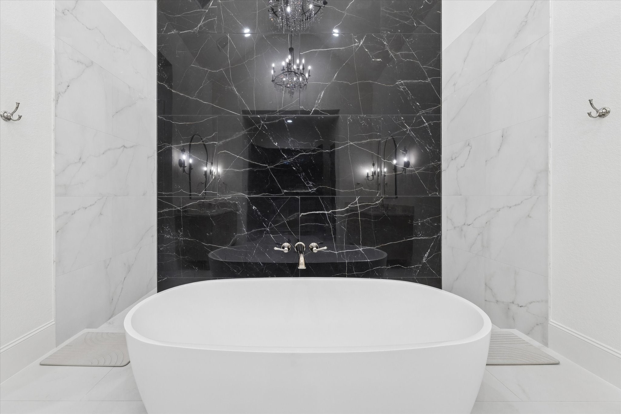 Anchored by a striking freestanding tub, this elegant retreat evokes the atmosphere of a private luxury spa. The dramatic stone feature wall creates a stunning focal point while enhancing the room's timeless sophistication.
