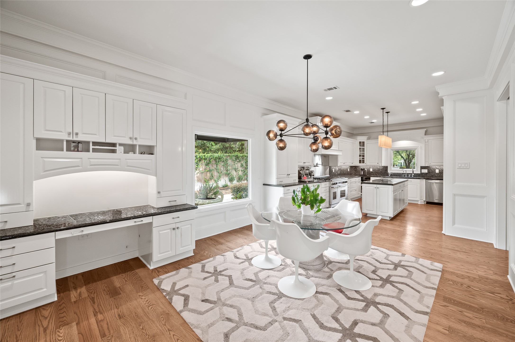[Gathering Kitchen]
Light-filled, open kitchen and breakfast area provides a casually elegant gathering spot for entertaining and day-to-day living. Appointments include granite countertops and a walnut floor. This view of the breakfast area reveals the large picture window.