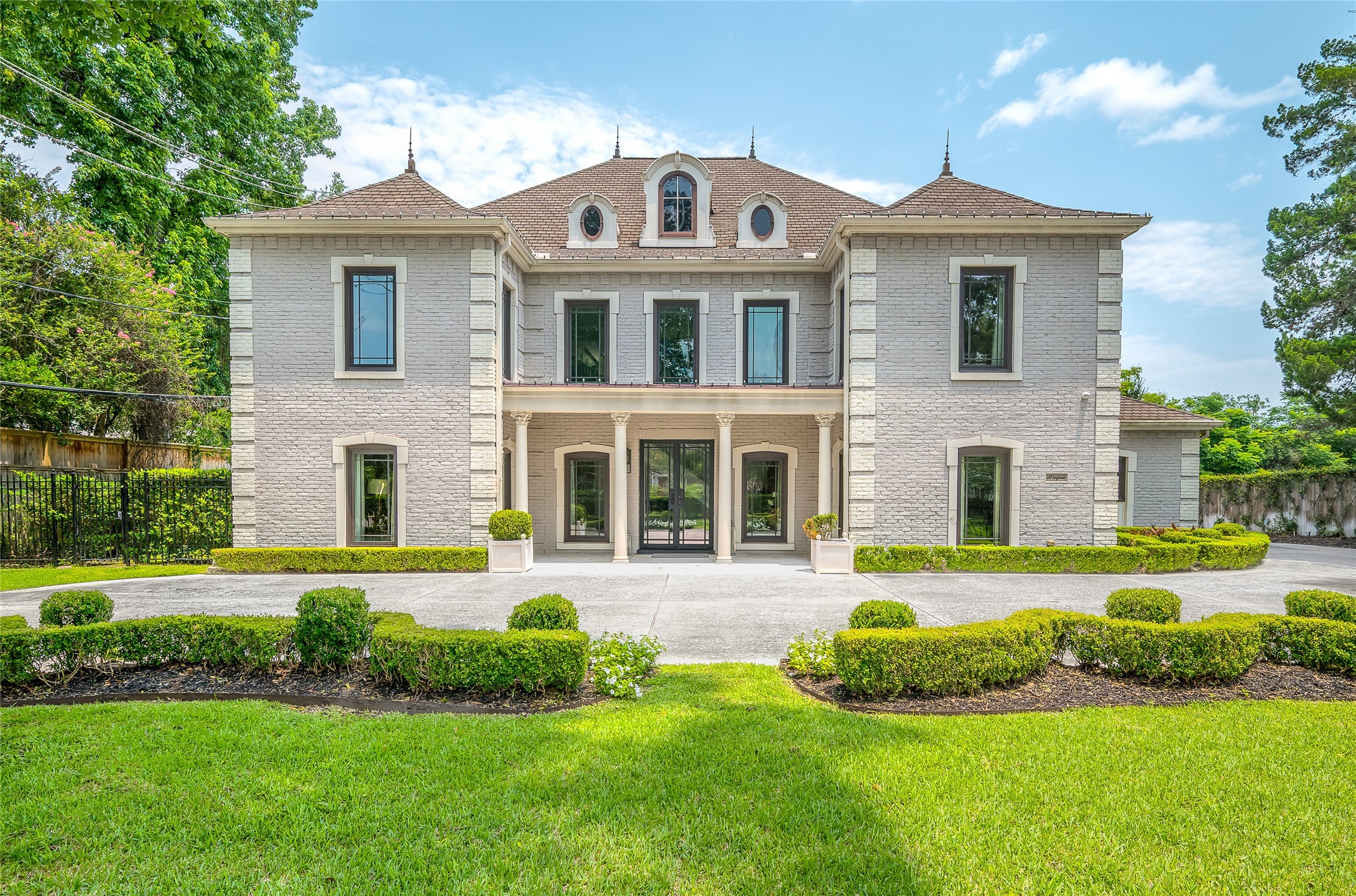 [Front Elevation]
Approached through a pair of auto-controlled driveway gates, this refined, French-inspired estate, an elegant landmark in the heart of River Oaks, presents a classic facade of quoins, balanced wings, hipped roof, and symmetrically placed windows.