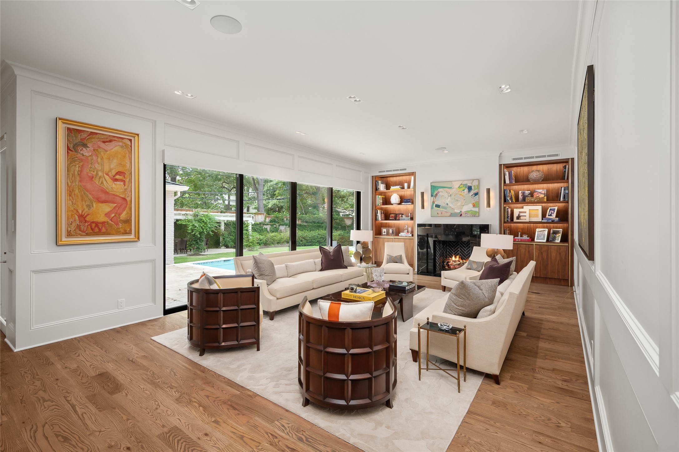 [Family Room]
Steel-framed windows and doors provide views of the pool as backdrop in the family room. Note marble surround on fireplace.