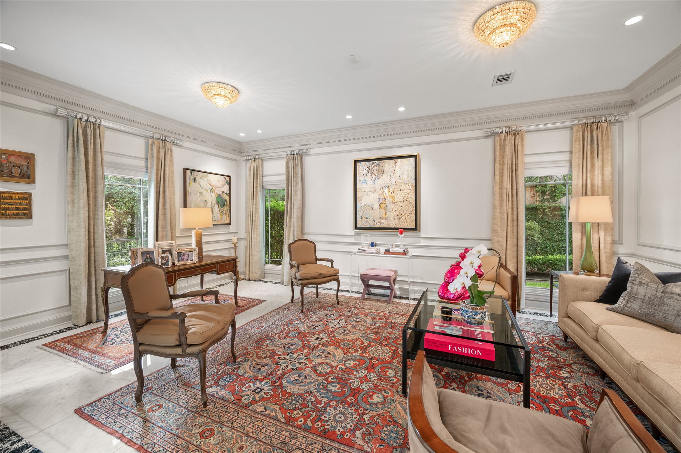 [Study]
Flanking the foyer, the large airy living room views front and side gardens through full-length casement windows. The foyer's marble floor extends into this room as well as the dining room.