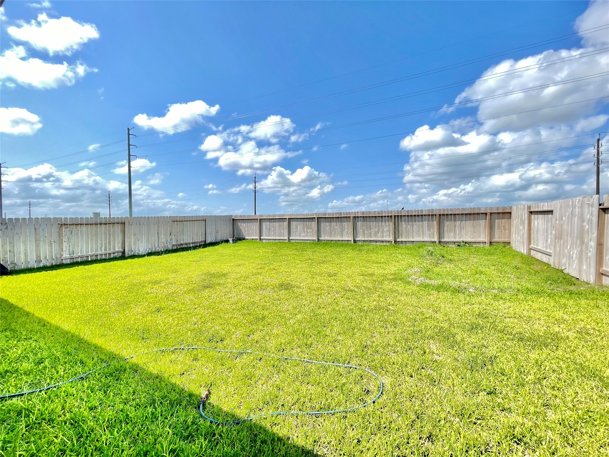 A massive, fully fenced backyard offering a completely blank canvas for a future pool, playground, or garden oasis.