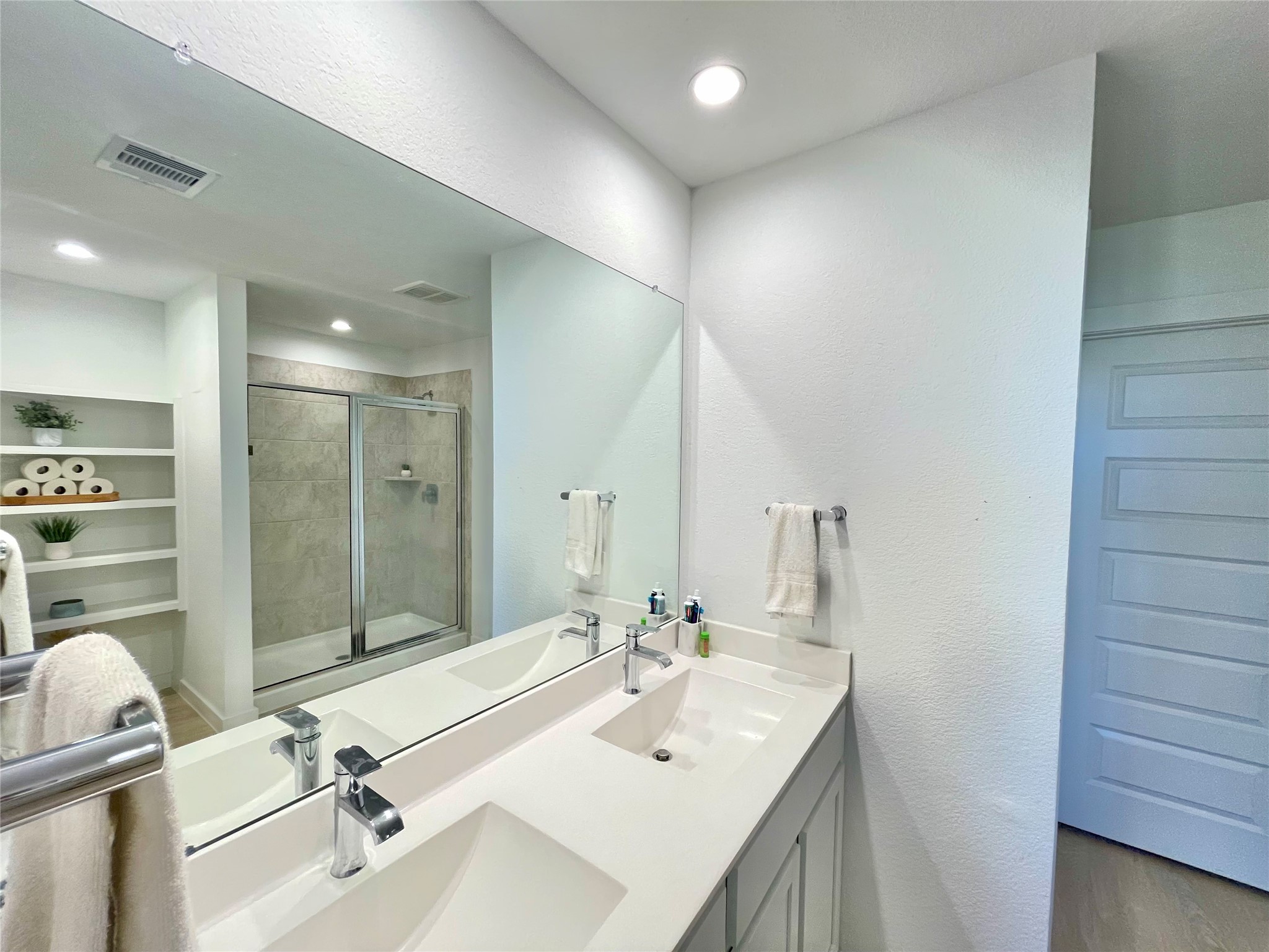 Spa-like primary bathroom equipped with an extra-wide double vanity, crisp modern finishes, and bright lighting.