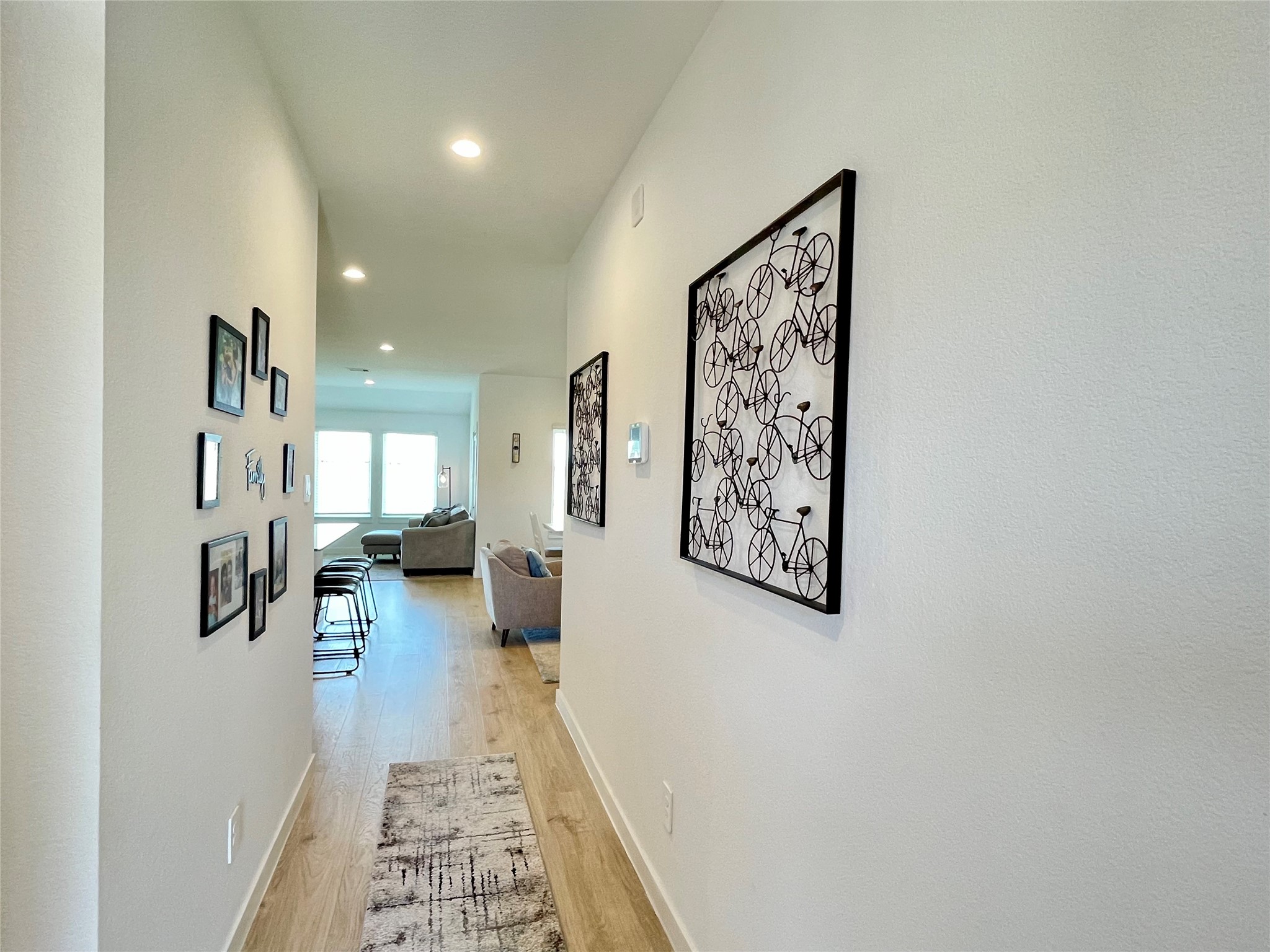 This beautifully lit corridor offers the perfect gallery wall potential, connecting the private quarters with sophisticated easeaccent furniture placement and a seamless transition into the heart of the home.