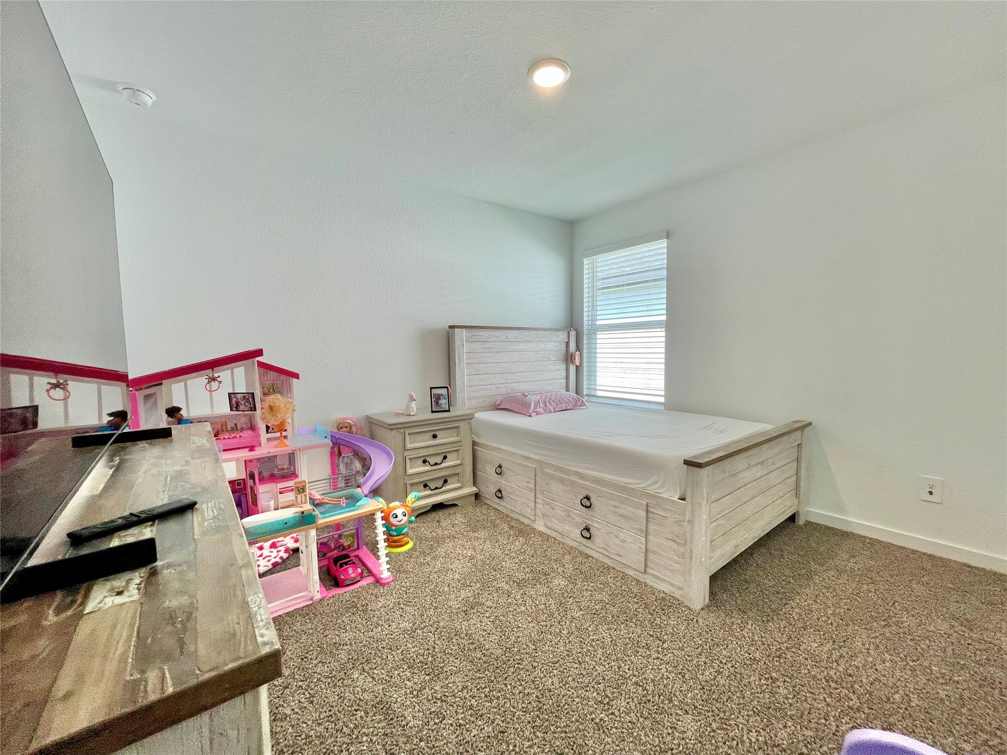 Another perspective of this cheerful bedroom showcases the generous floor plan, leaving plenty of room for play areas and toy storage.