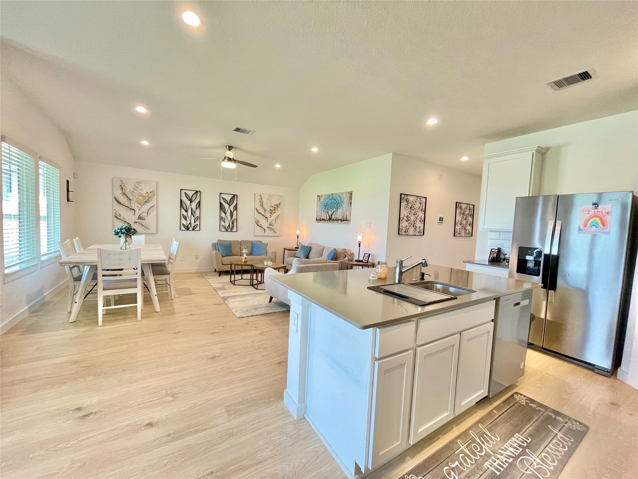 A sweeping panoramic view from the kitchen prep station out into the expansive, sun-drenched great room.