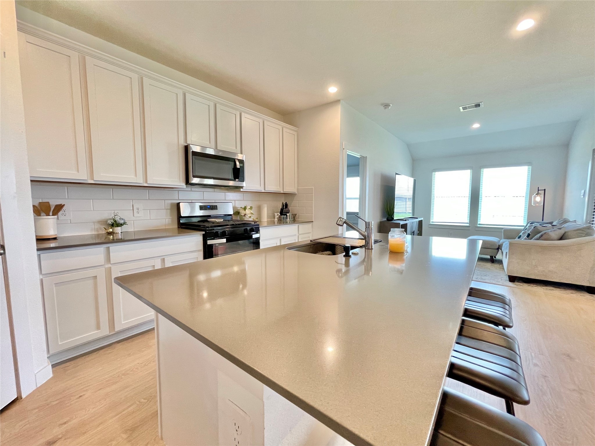 Premium countertops and generous breakfast bar seating make this kitchen as highly functional as it is visually stunning.