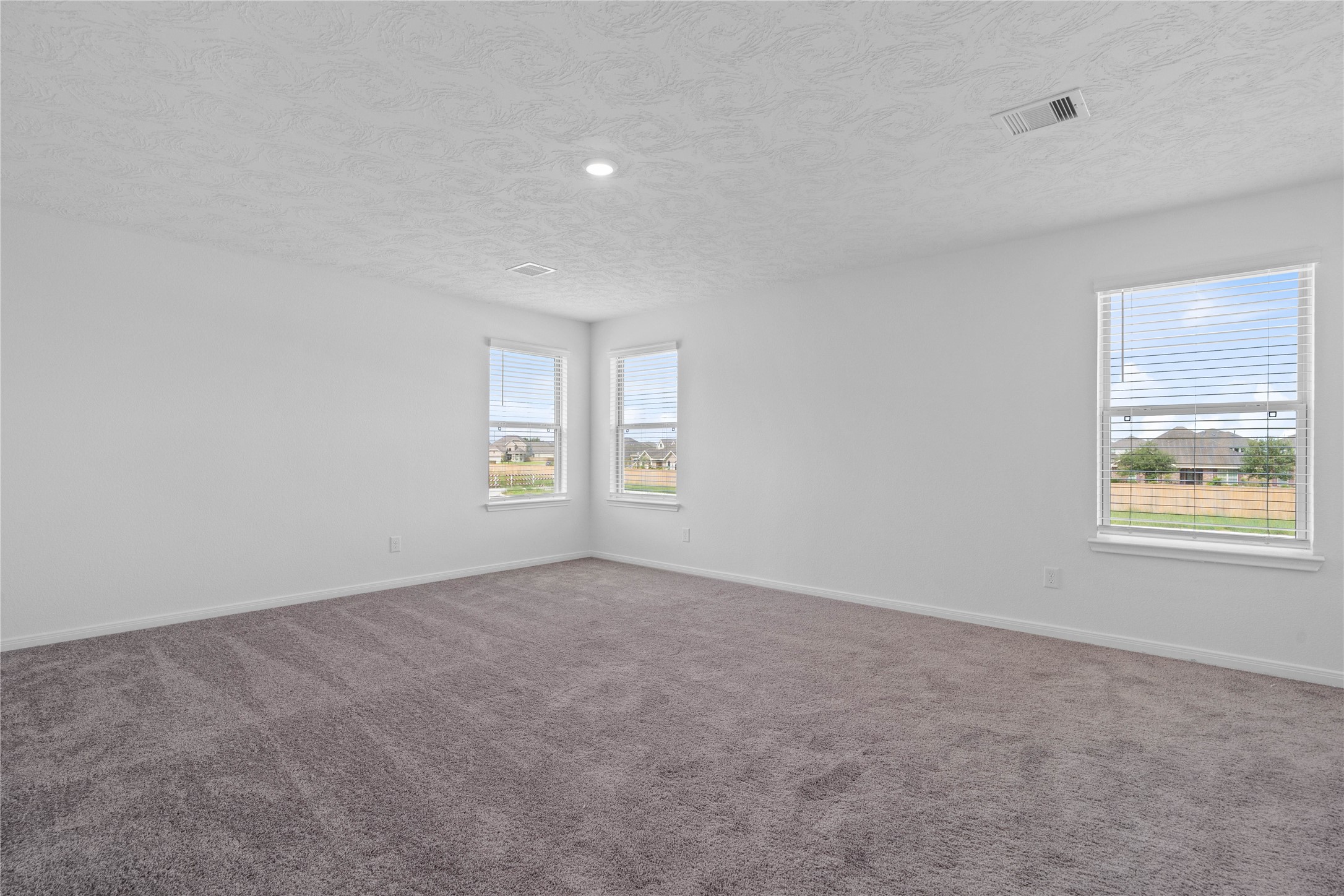 Come upstairs and enjoy a day of leisure in this fabulous and spacious game room! This is the perfect hangout spot or adult game room, this space features plush carpet, high ceiling, recessed lighting, custom paint and plenty of windows that will add natural light!