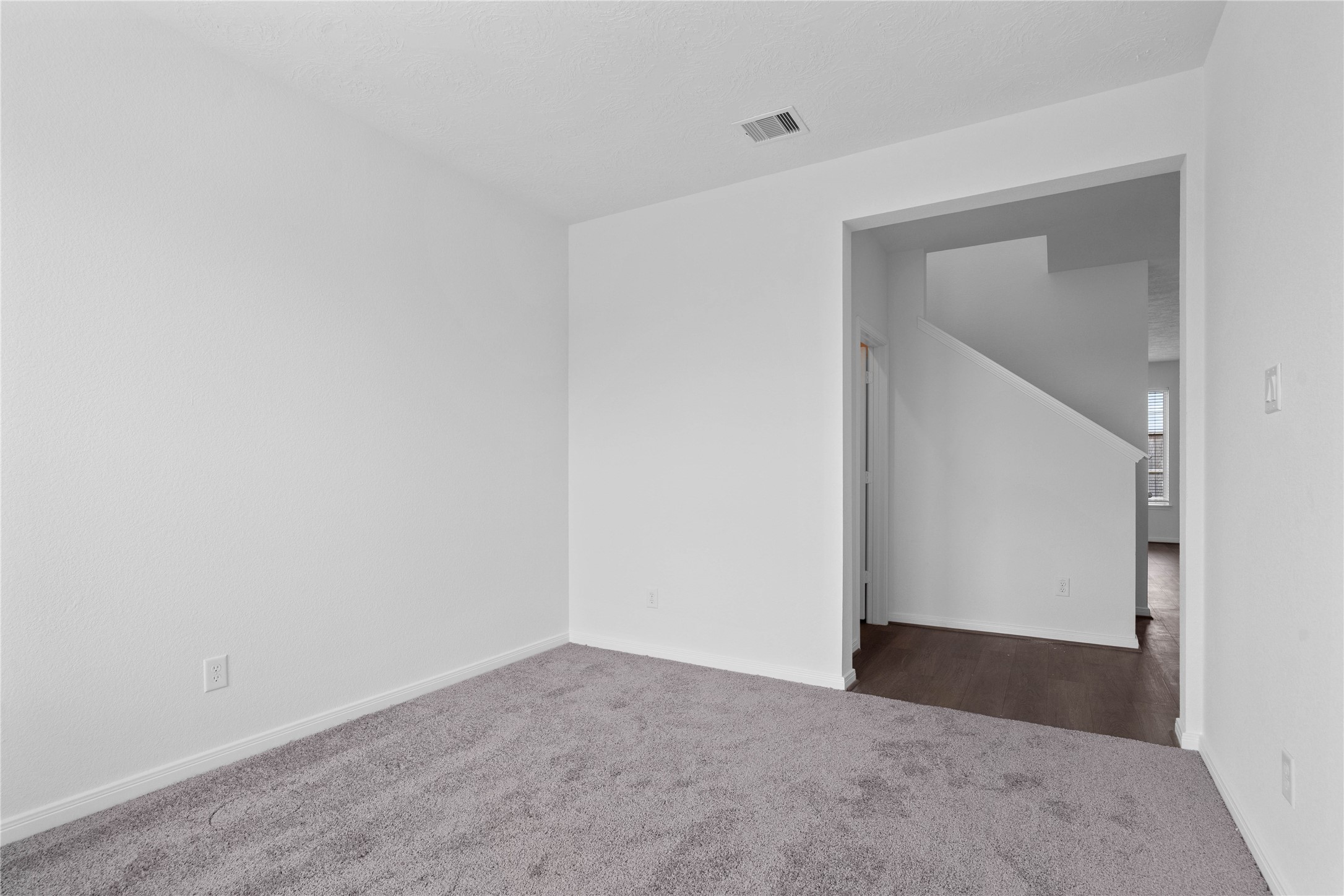 Additional view from Den into hallway. On the left is the powder room and stairs. The Great Room is beyond the staircase.