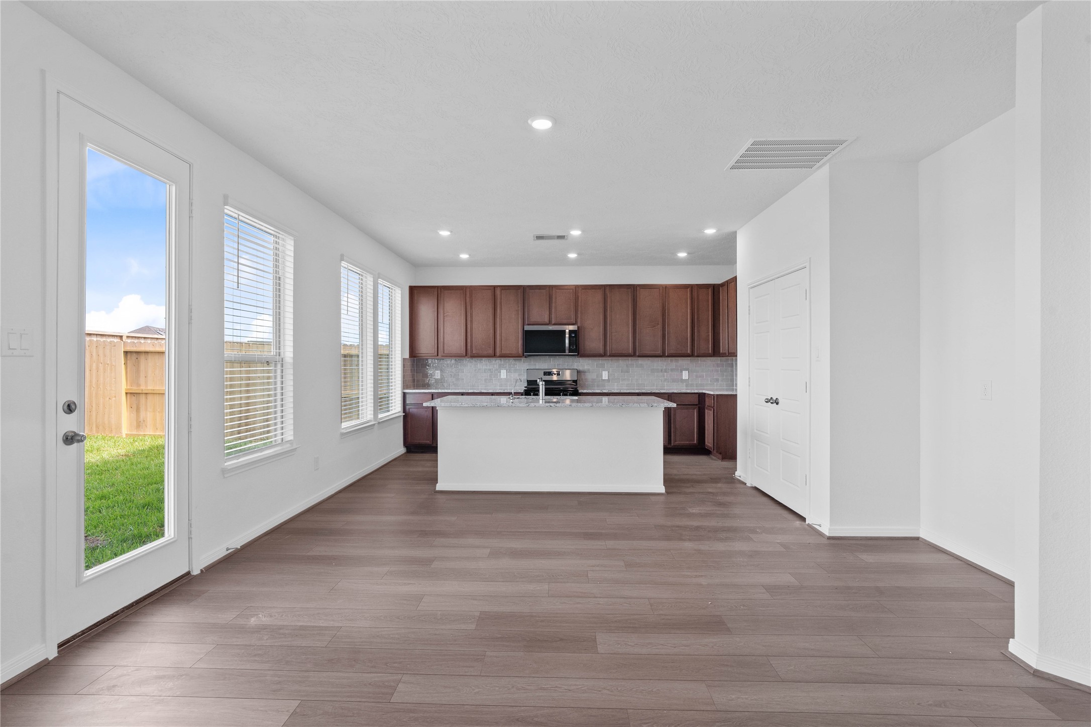 Make memories gathered around the table with your family and friends! This dining room features high ceilings, large windows, and easy access to the kitchen and family room. A patio door is also featured through this dining area into the backyard green space.
