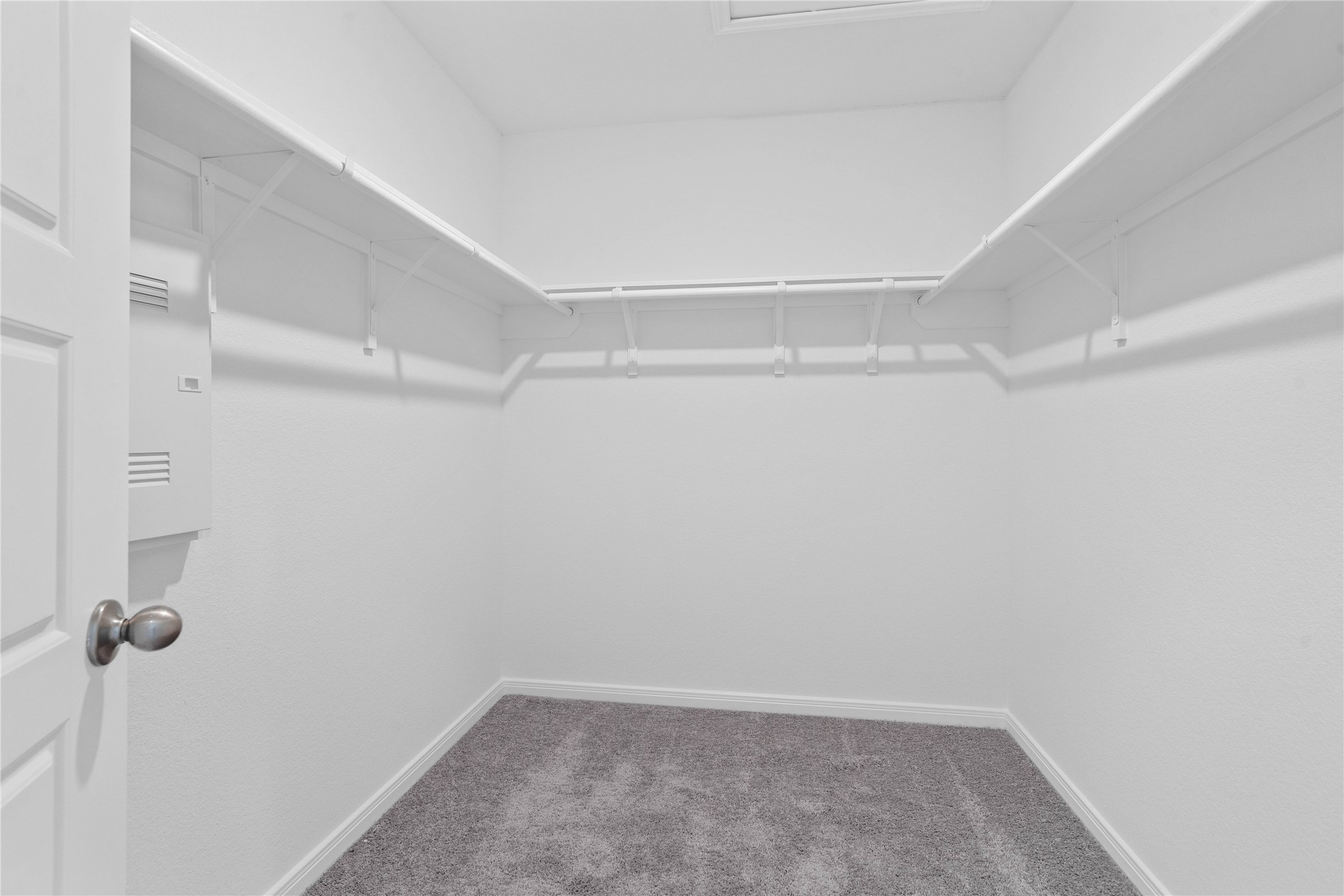 The primary walk-in closet features high shelving for seasonal storage while keeping your daily essentials within reach.