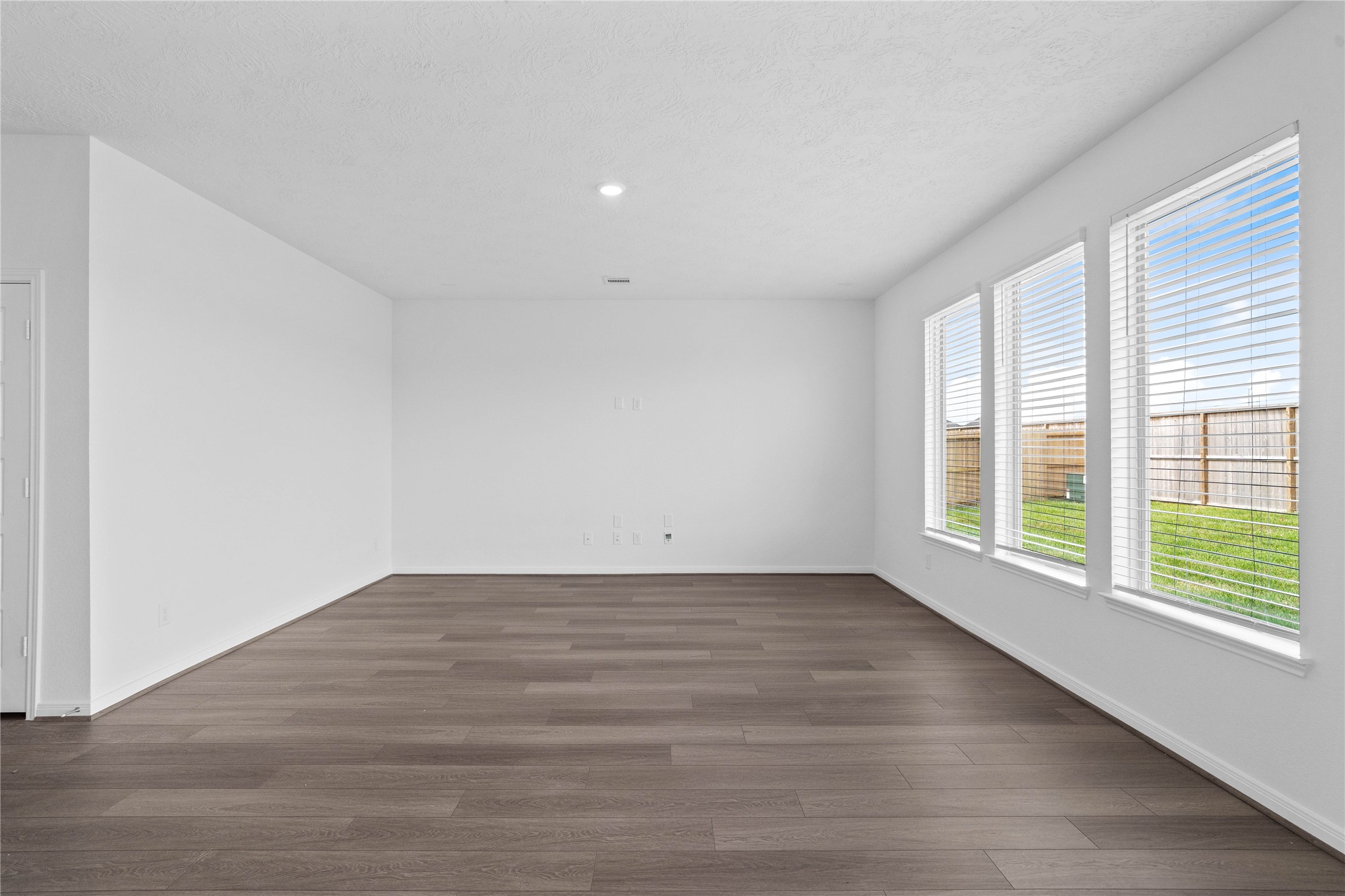 This light and bright spacious Great Room is the perfect layout for entertaining or just relaxing. Whether it's simply a night in or entertaining family and friends, this home has ample open space for everyone to enjoy! Featuring vinyl plank flooring, large windows with blinds, high ceilings, recessed lighting, and wonderful access to the kitchen and dining area.