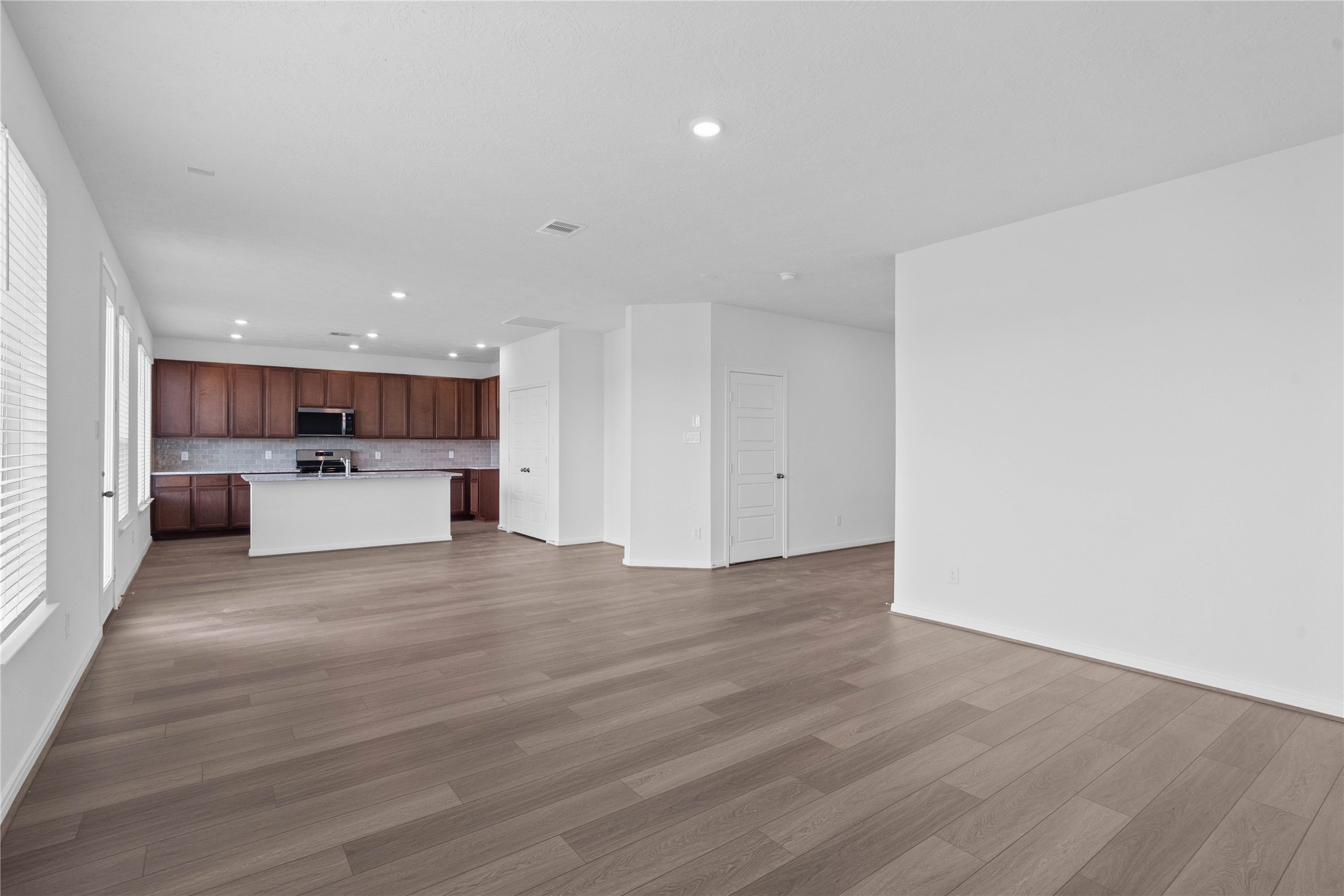 Experience the ultimate in open-concept living with this expansive and sun-drenched main floor layout. The seamlessly connected space provides a versatile footprint, tying the kitchen and living areas together into one cohesive environment.