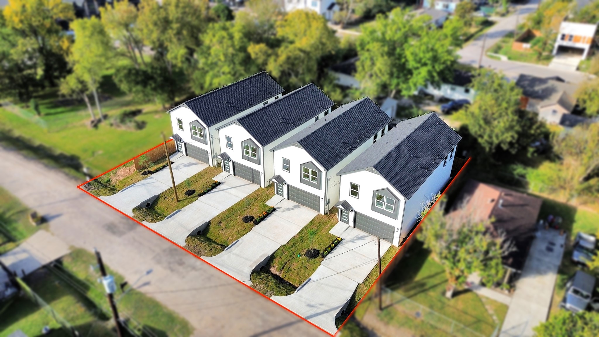 Additional aerial view highlighting the four neighboring new construction homes, their matching architectural styles, individual lots, fenced yards & surrounding properties.