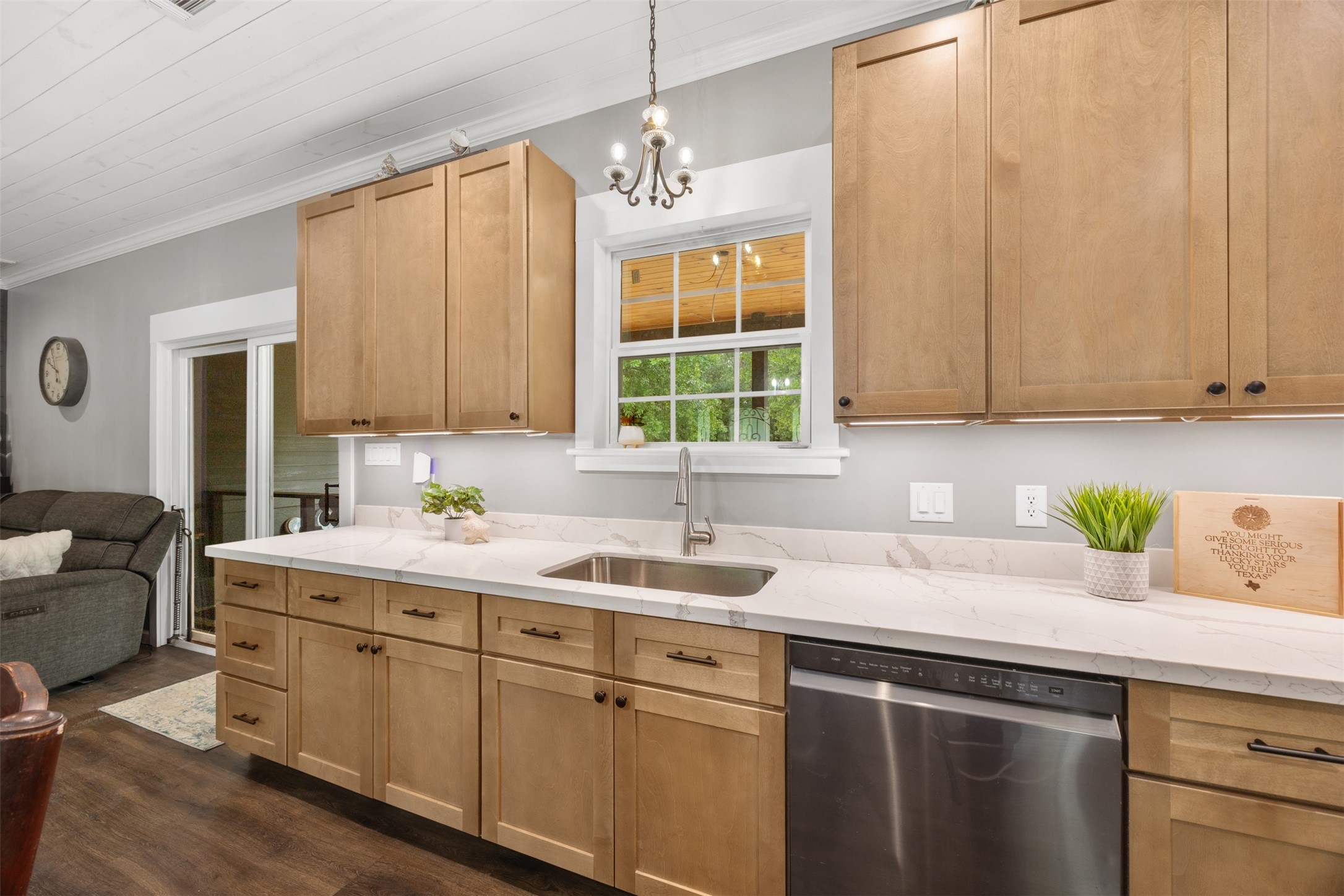 Kitchen has under counter lighting along with cute hanging light over the sink. Sink window overlooks back porch