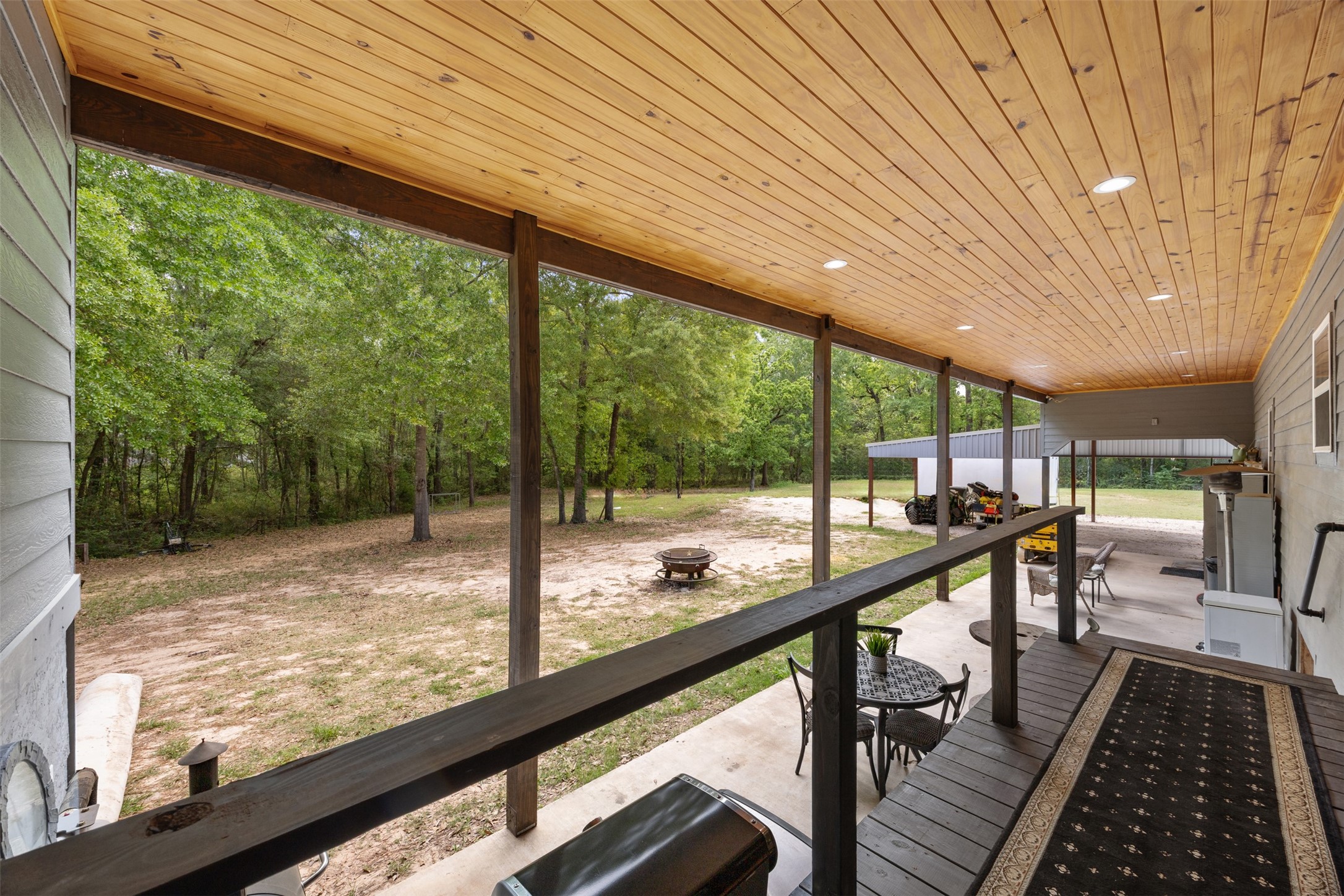 From the utility room exit, views of the back porch with outdoor entertaining and views of the wooded 2.5 acre lot