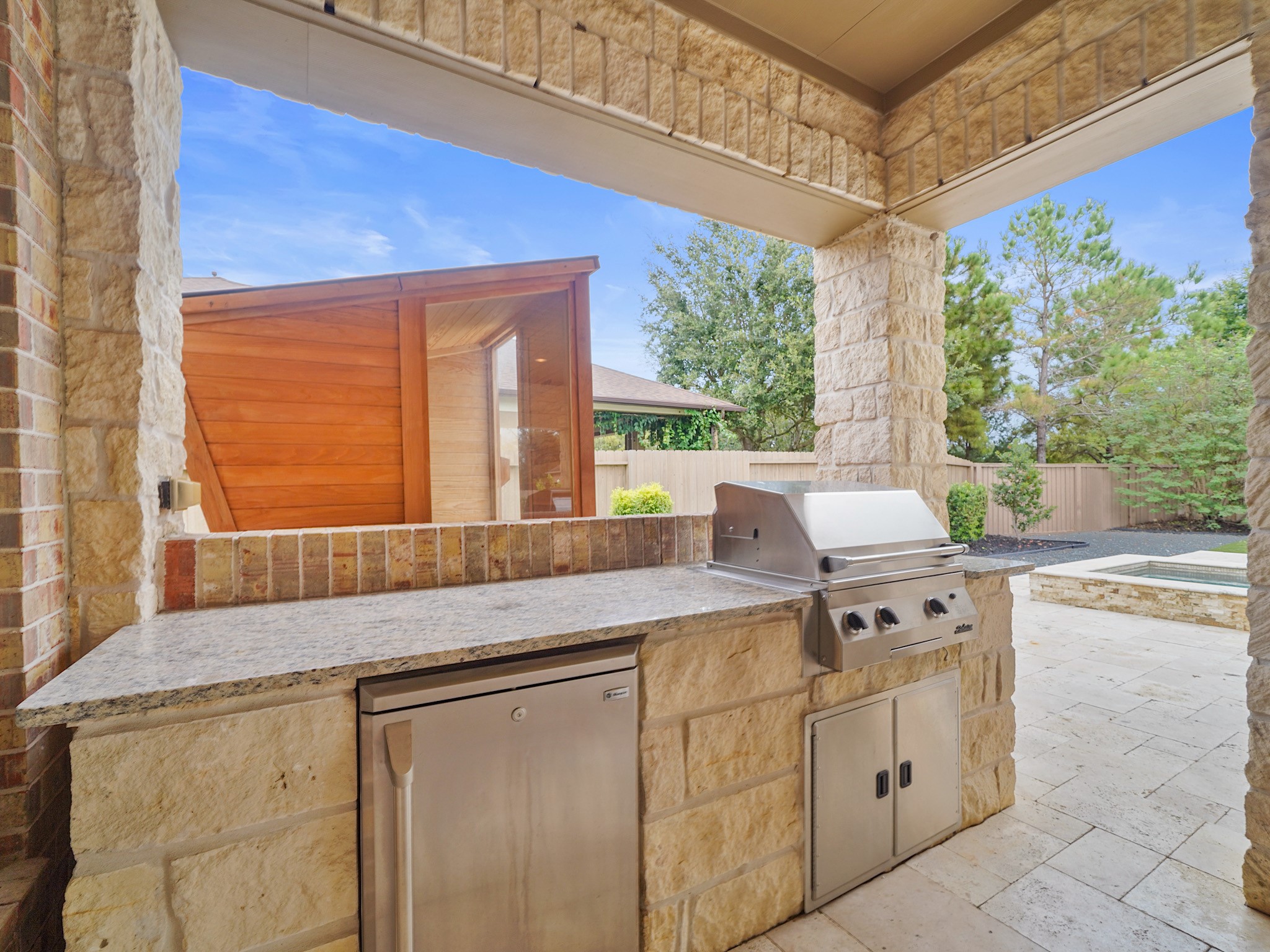 The outdoor kitchen is ready for relaxed weekend dinners, with a built-in grill and generous counter space for serving.