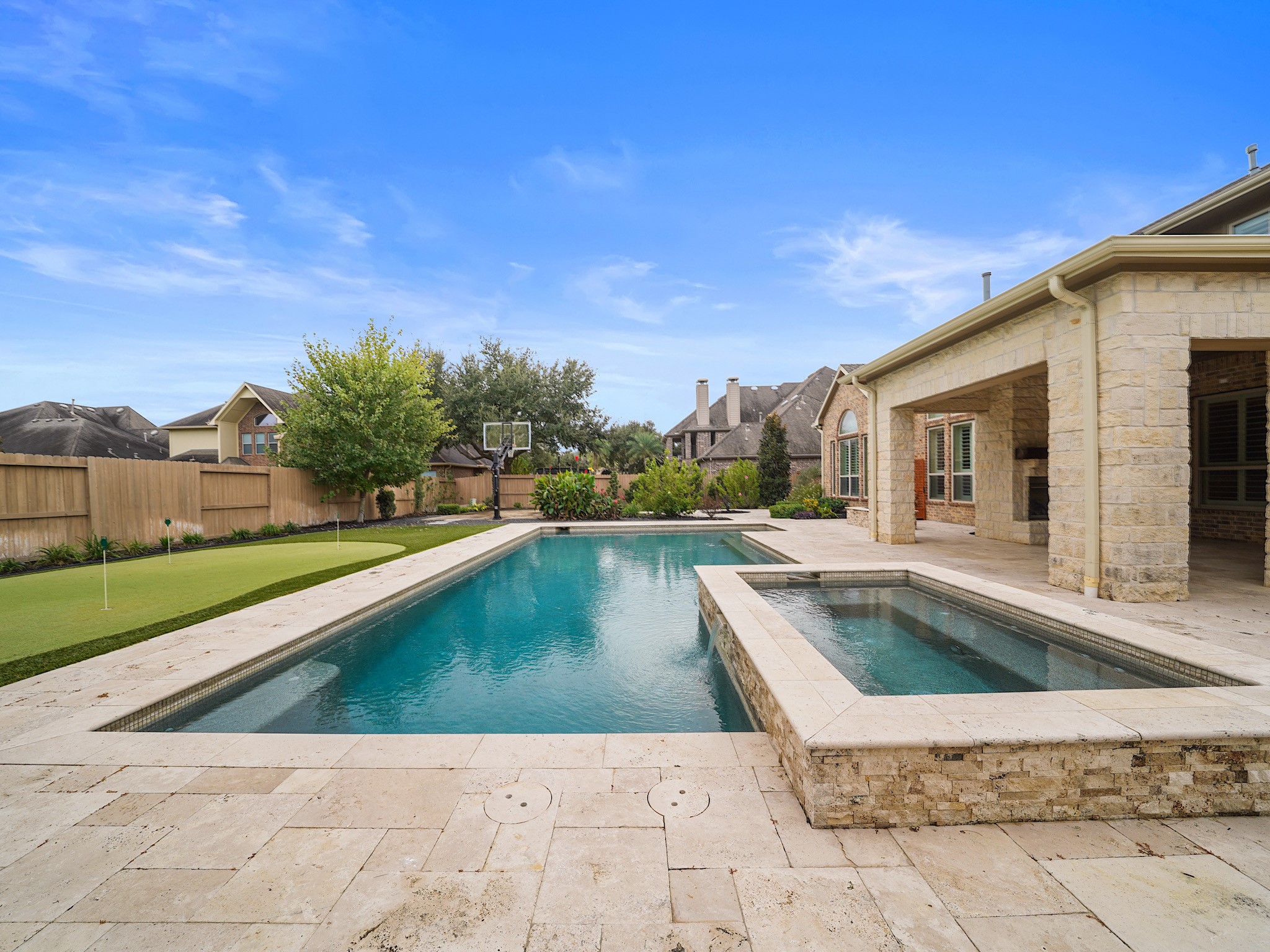 From this angle, the sculpted waterline and stone surround lend the pool area a polished, resort-inspired finish.