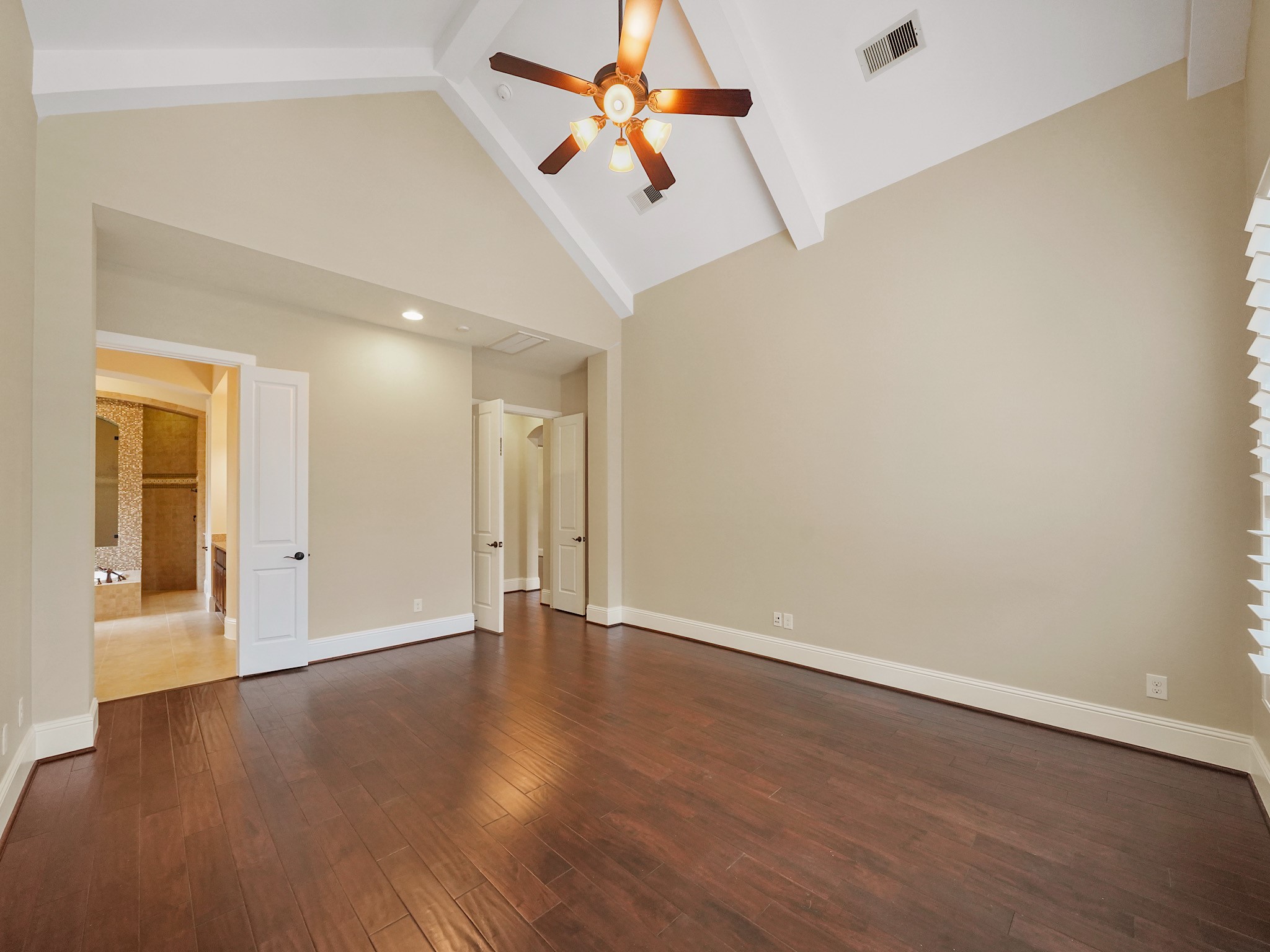 From the opposite side, the primary suite unfolds as a true retreatquiet, open, and intentionally set apart from the homes daily pace.