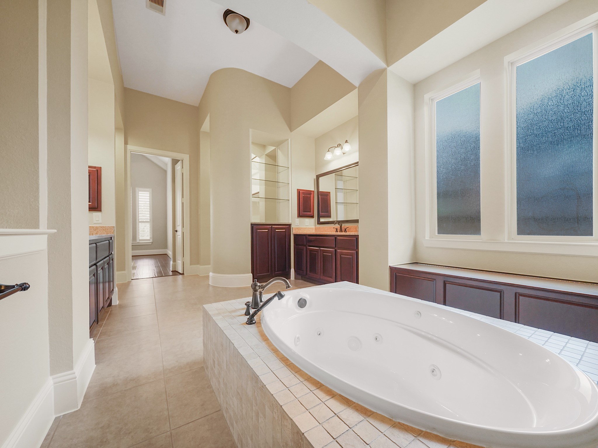 Imagine yourself unwinding at the end of the day in this spa-like primary ensuite, where a jetted soaking tub invites you to linger, dual vanities simplify the morning routine, and the walk-through shower with multiple showerheads elevates every day.