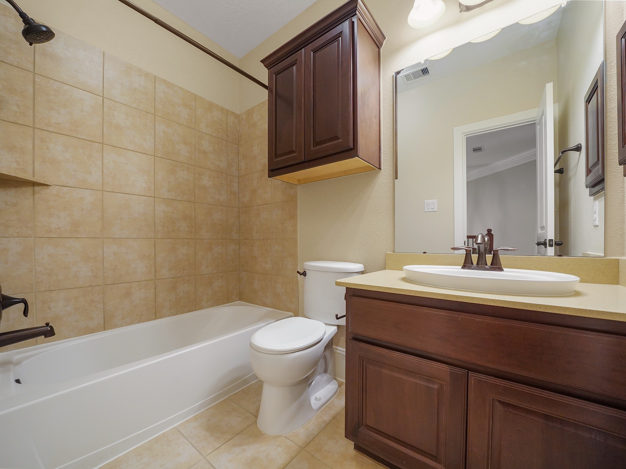 A nearby full bath pairs a tub/shower combination with a warm wood vanityan easy fit for busy mornings or overnight guests.