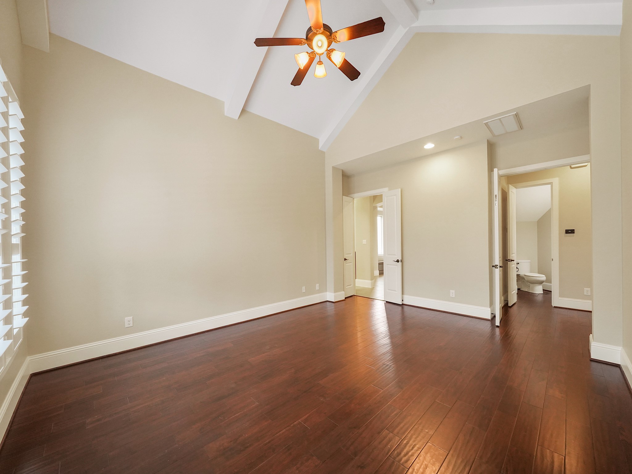 Vaulted ceilings amplify the primary bedrooms generous proportions, leaving ample room for a sitting area beside the bed.