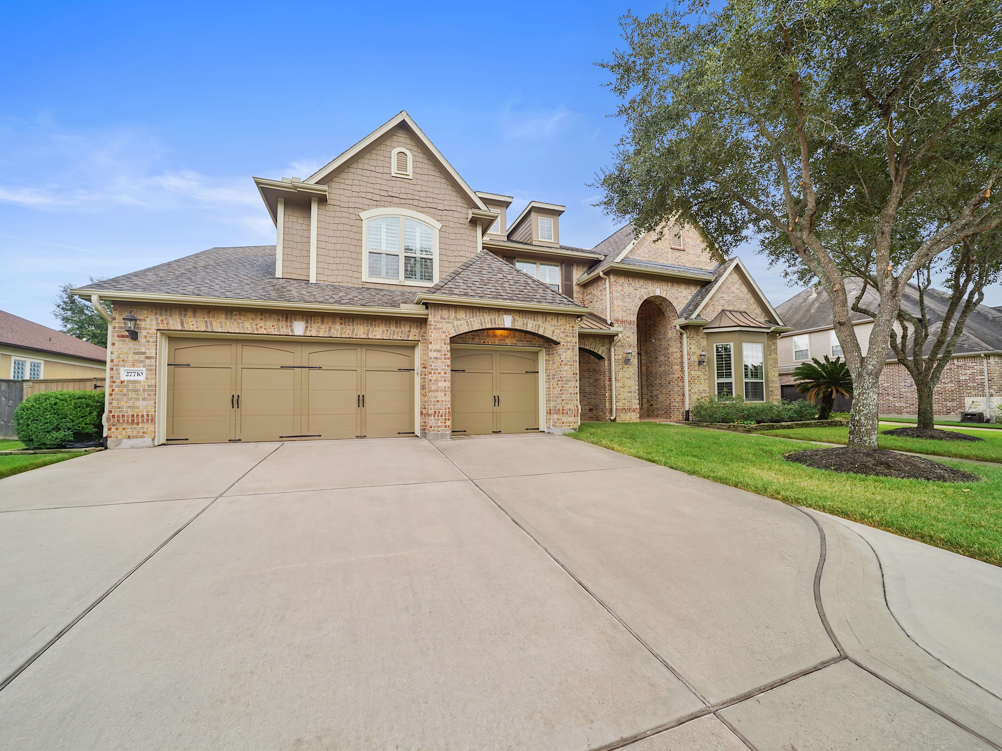 A sweeping driveway and three-car garage create a polished arrival for guests and everyday living.