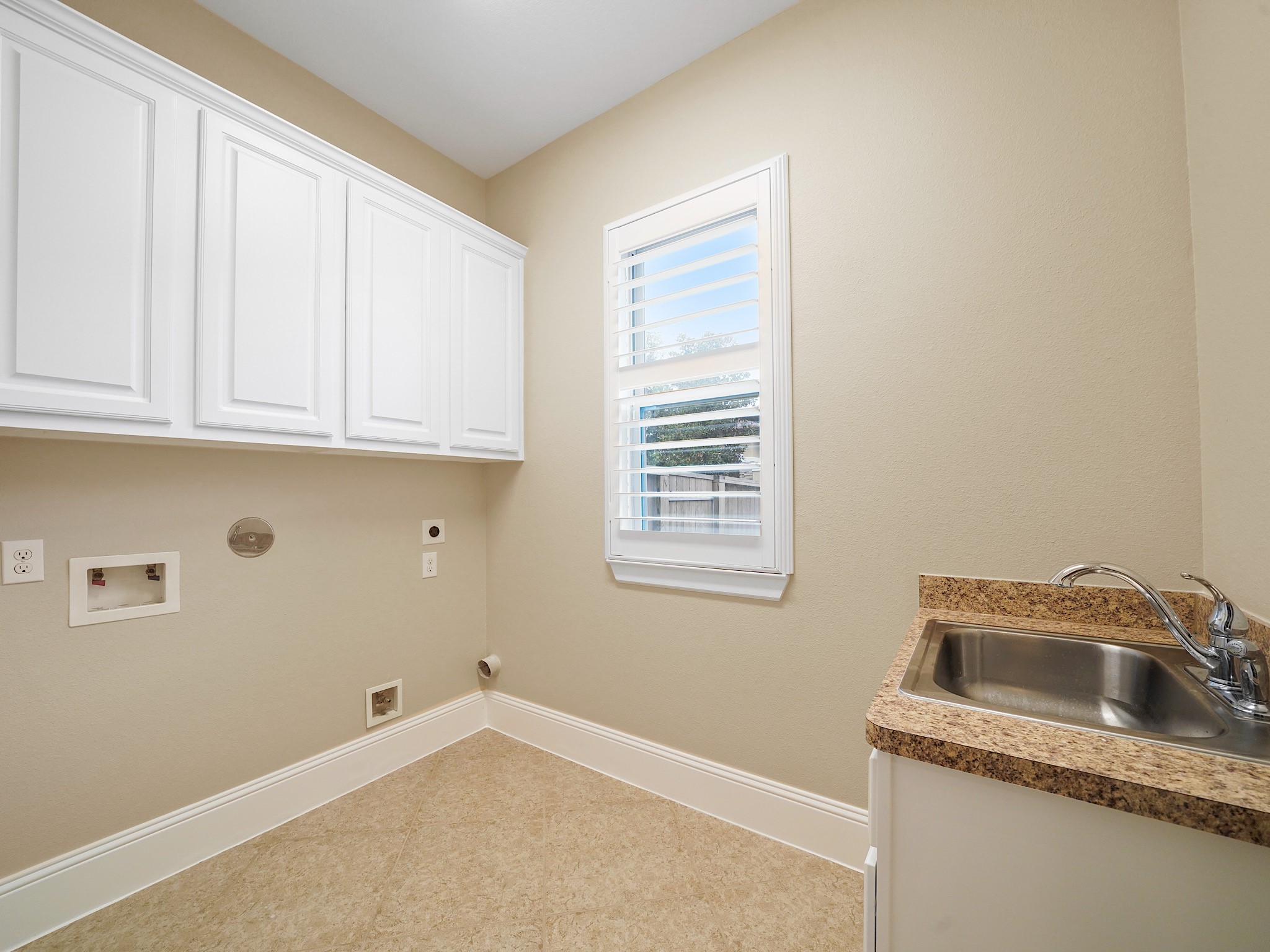 Beyond the main living spaces, the utility room pairs practical cabinetry and generous workspace for polished everyday function.