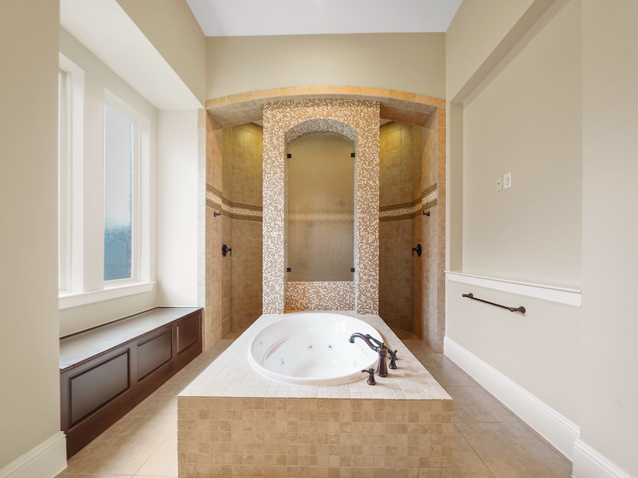 At its center, the jetted soaking tub invites a quiet end-of-day ritual within the spacious, light-filled ensuite. While  the walk-through shower raises the bar with multiple showerheads and striking tilework, making an everyday routine feel a little more indulgent.
