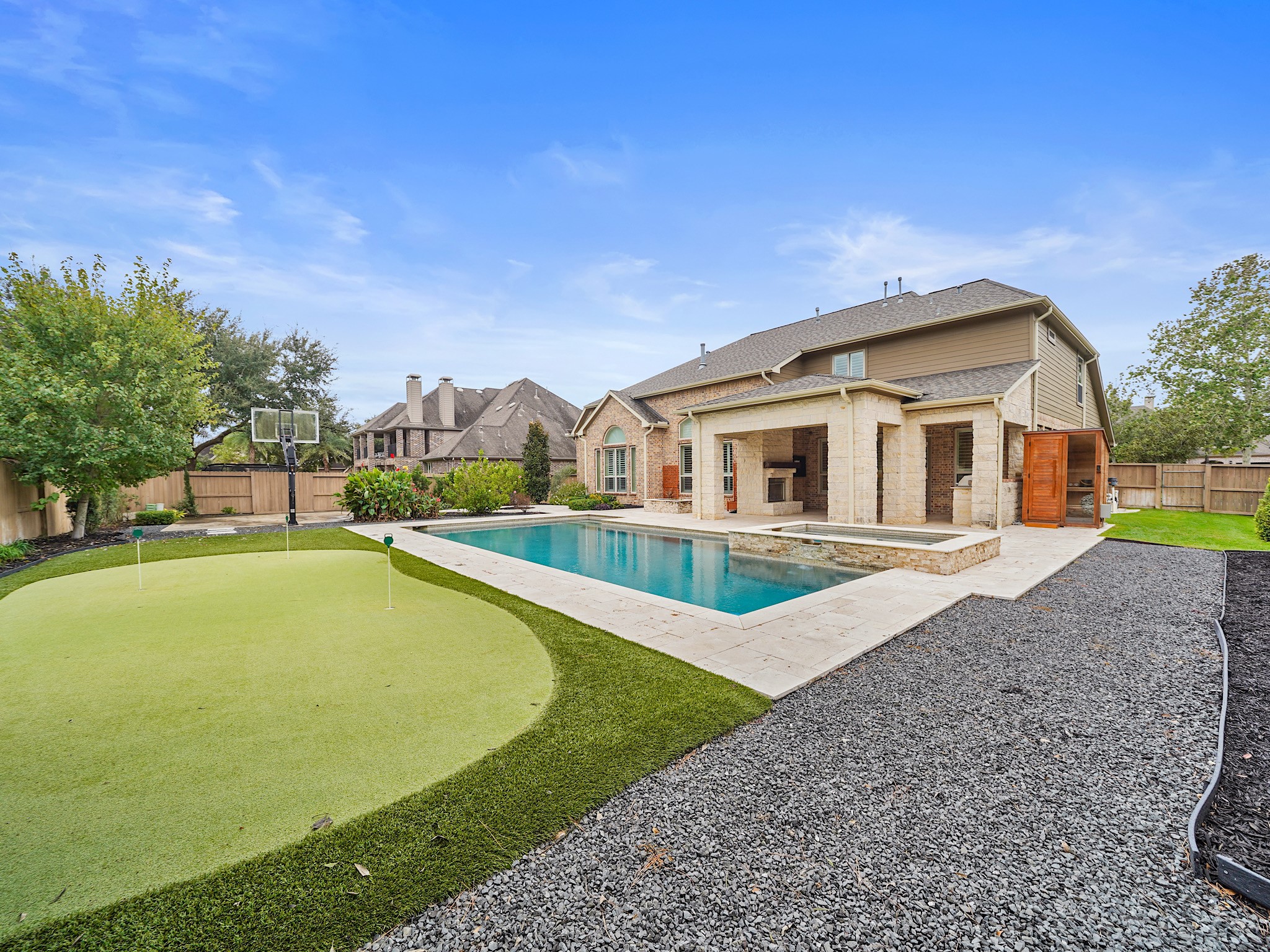 Just beyond the back door, a sprawling outdoor retreat beckons with spaces to swim, gather, dine, and play under the Texas sky.