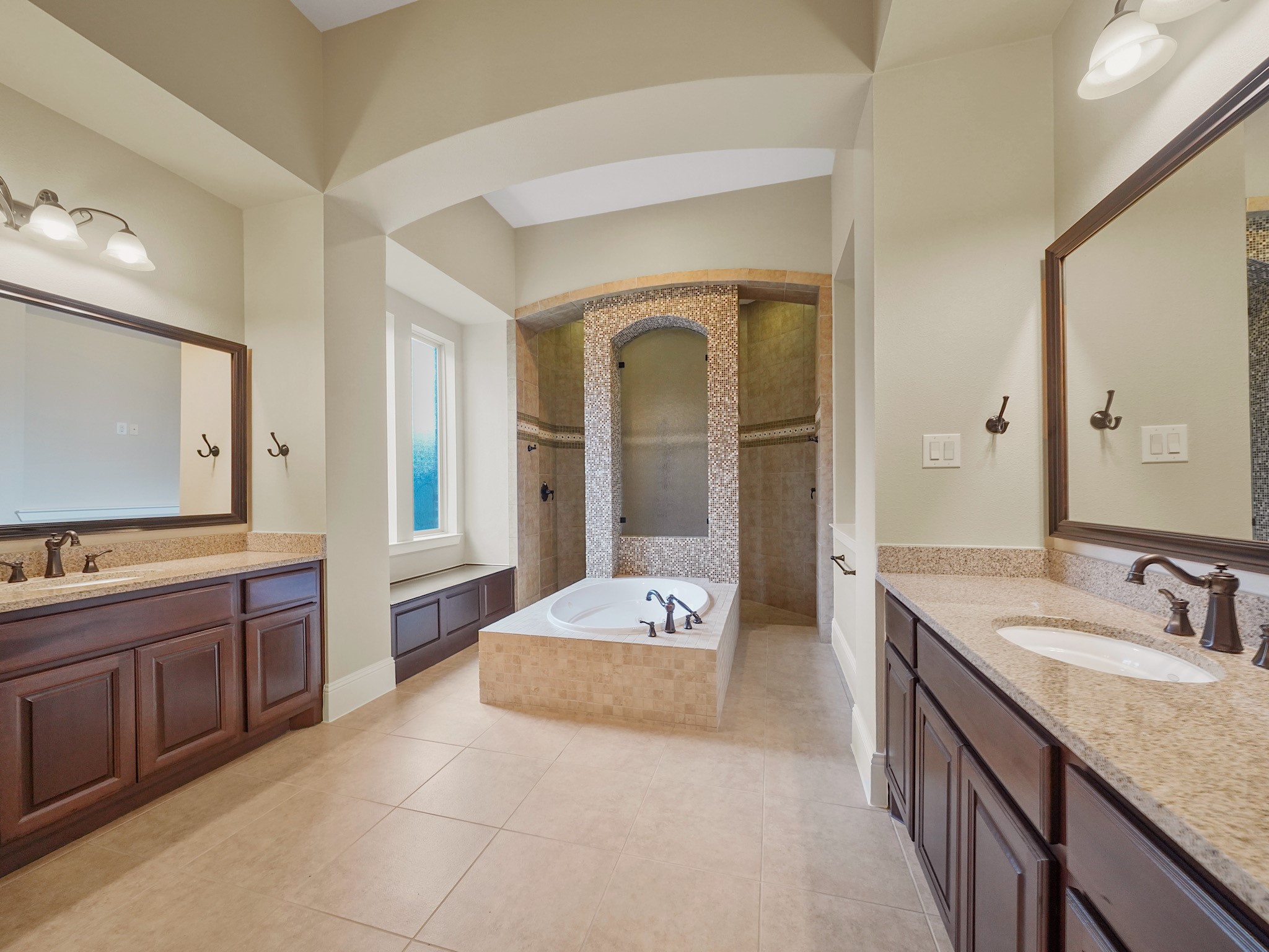The primary ensuite feels like a private spa, with a jetted soaking tub, dual vanities, and an expansive walk-through shower outfitted with multiple showerheads.