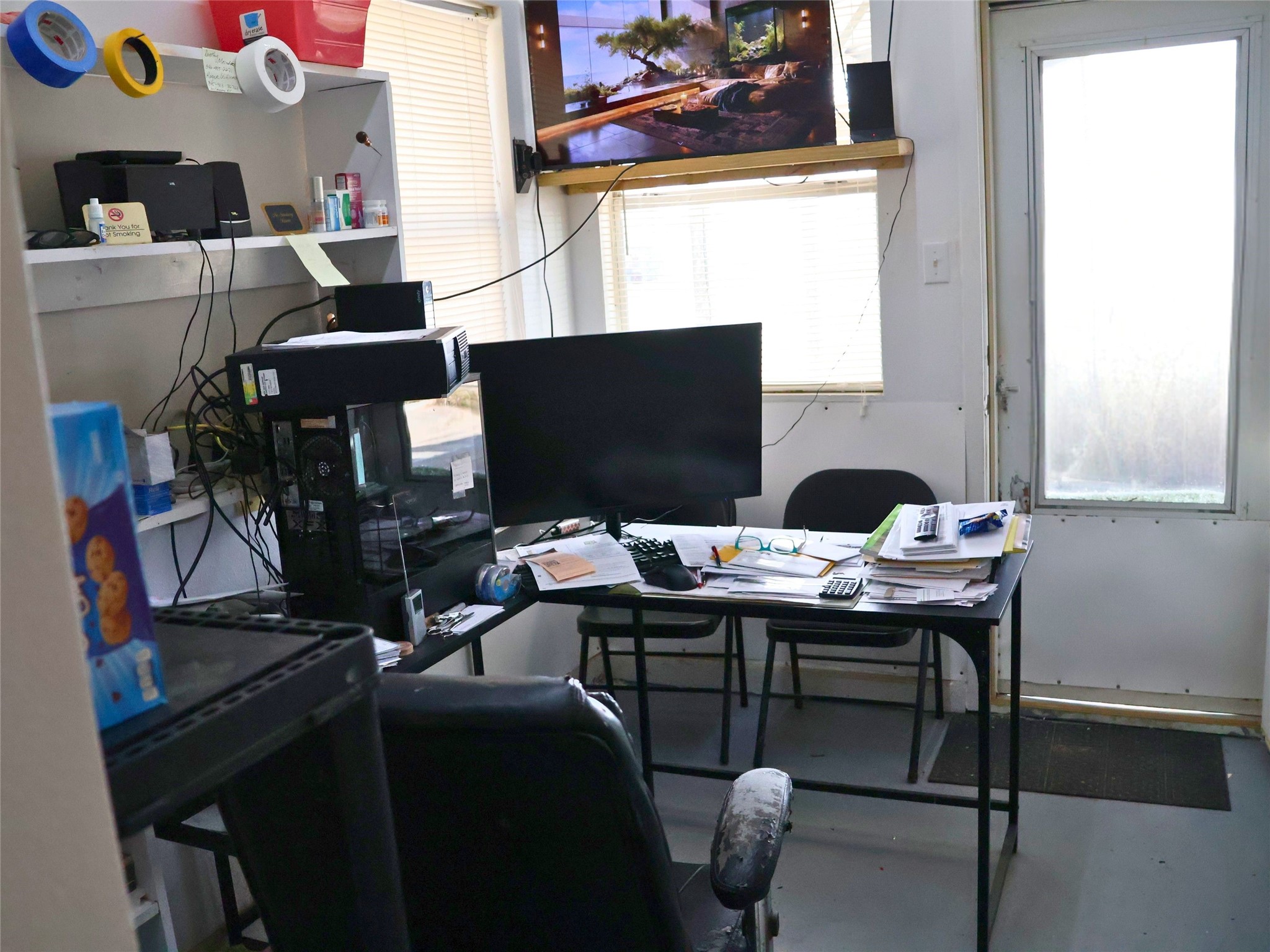Office entry area with dedicated workspace, including desk, computer setup, and seating for added comfort.