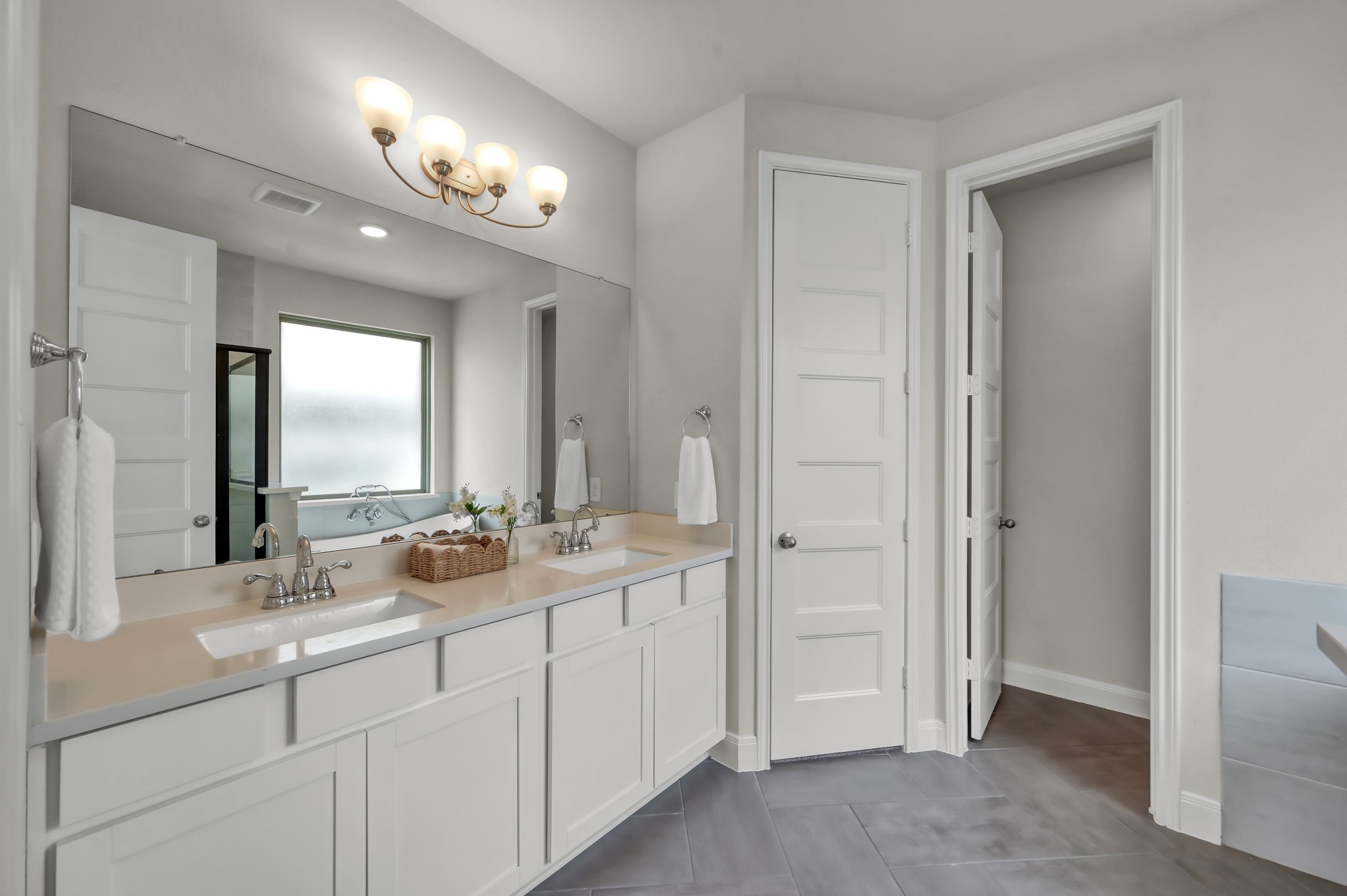 Primary bath with dual vanities, ample storage, and clean, modern finishes.