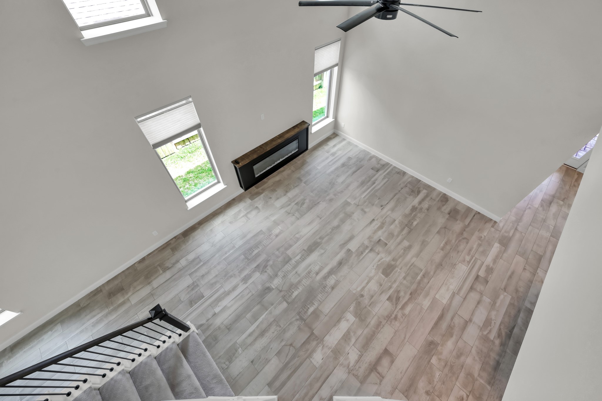 Overlook from above highlighting soaring ceilings, open layout, and modern fireplace focal point.
